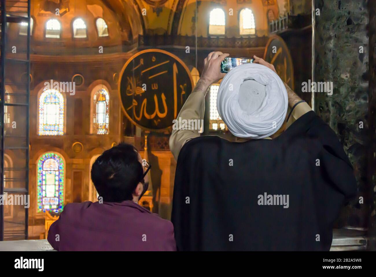 Ein Imam fotografiert mit einem Smartphone, während er das Hagia Sofia Museum, Istanbul, Türkei besucht Stockfoto