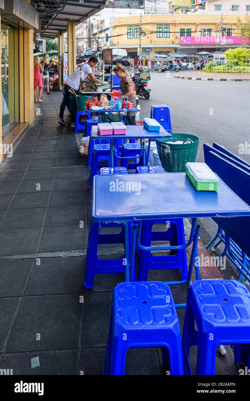 Plastiktische und Stühle auf dem Fußweg vor einem Restaurant, Bangkok, Thailand. Stockfoto