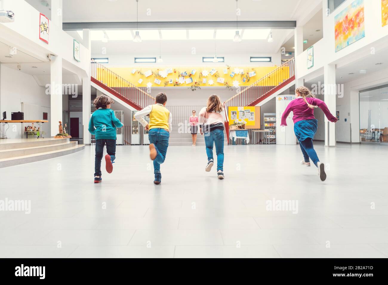 Schüler, die in der Schulhaupthalle zu ihren Klassen laufen Stockfoto