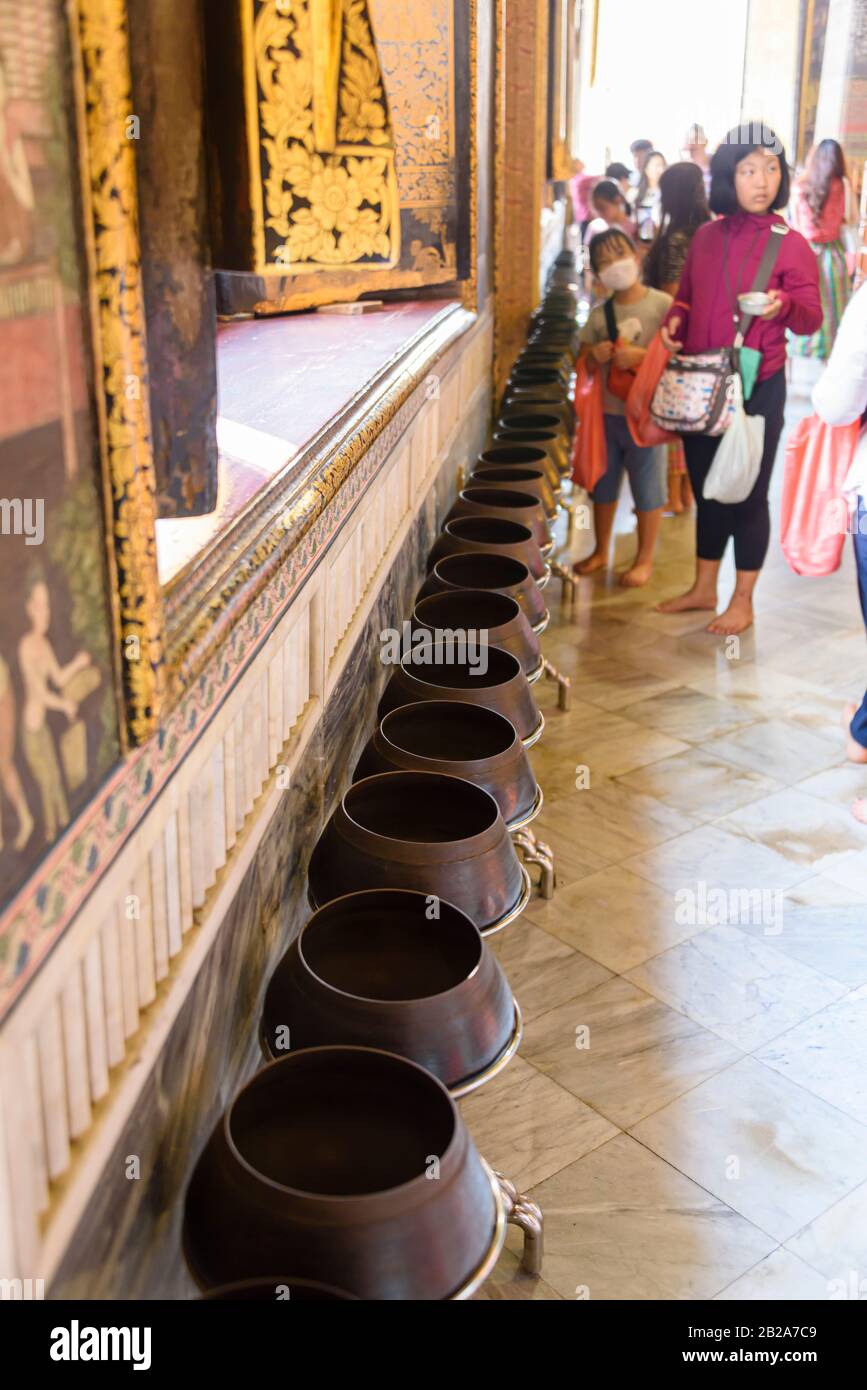 Einige von 108 alten Messingschüsseln mit Münzen im Wat Pho. Es wird angenommen, dass das Platzieren von Münzen in ihnen viel Glück bringt. Bangkok, Thailand Stockfoto