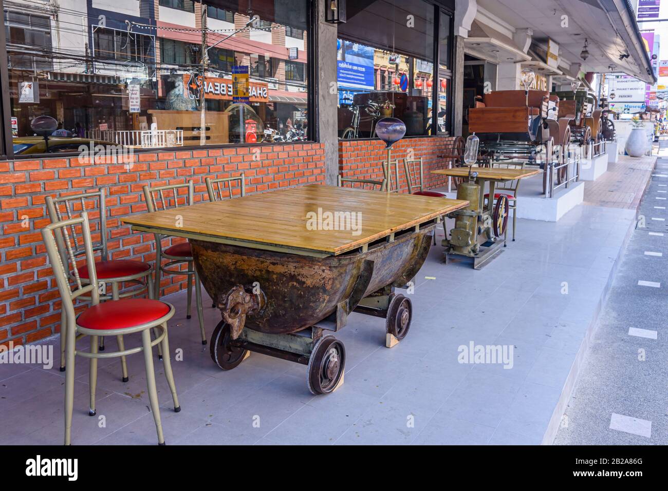 Tische aus Bergwagen mit halbem Fass vor einem Restaurant in Phuket, Thailand Stockfoto