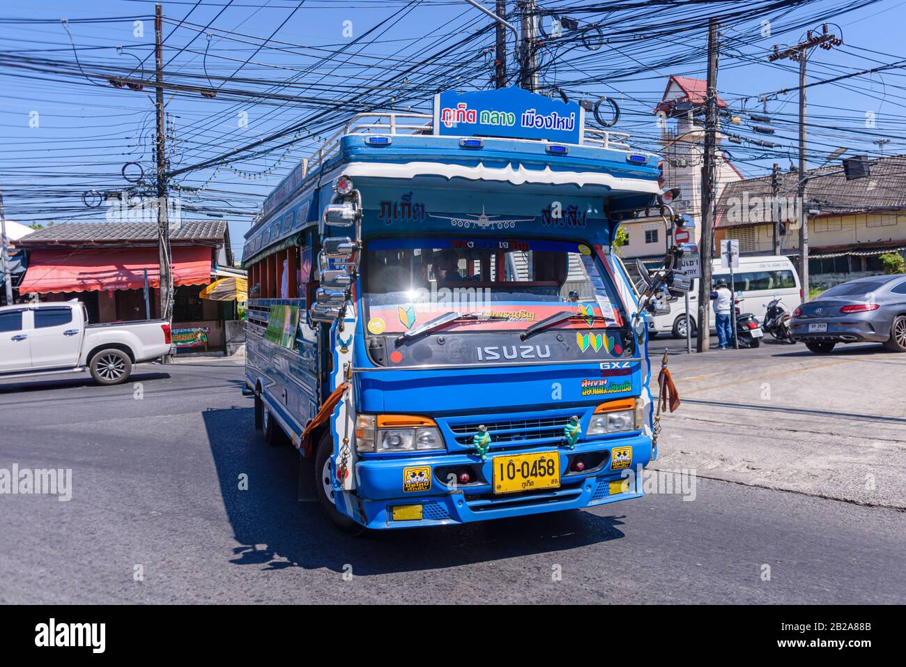 Der Bus Phuket nach Kata führt an einem Strompfosten in Thailand vorbei an unordentlichen und unsauberen elektrischen Kabeln Stockfoto