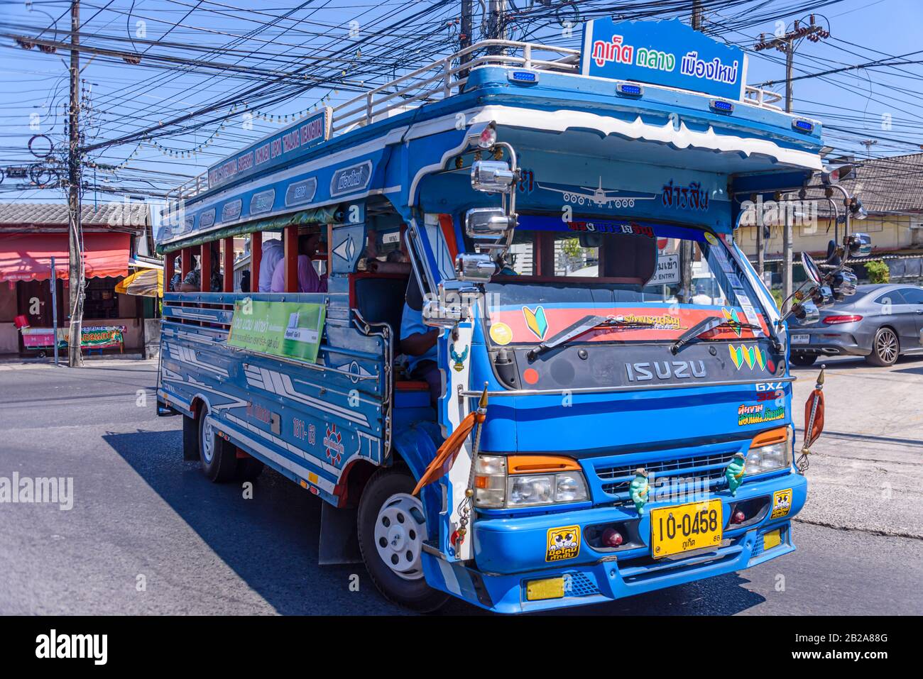 Unordentliche und unsaubere elektrische Kabel, die an einem Strompfosten in Thailand hängen Stockfoto