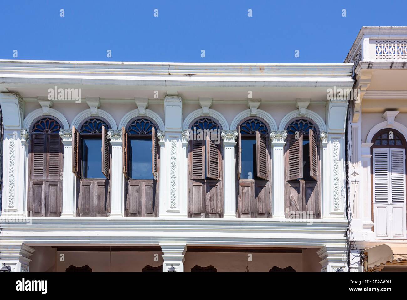 Apartment mit Fensterläden aus Holz über Geschäften in Phuket, Thailand Stockfoto