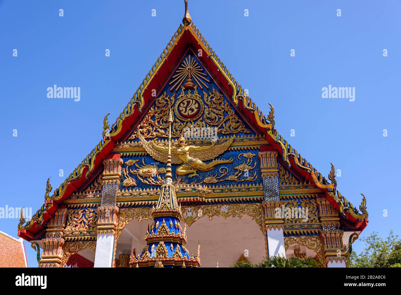 Verzierter Dachreiter und goldene Statue im Wat Mongkhon Nimit Buddhist Temple, Phuket Old Town, Thailand Stockfoto