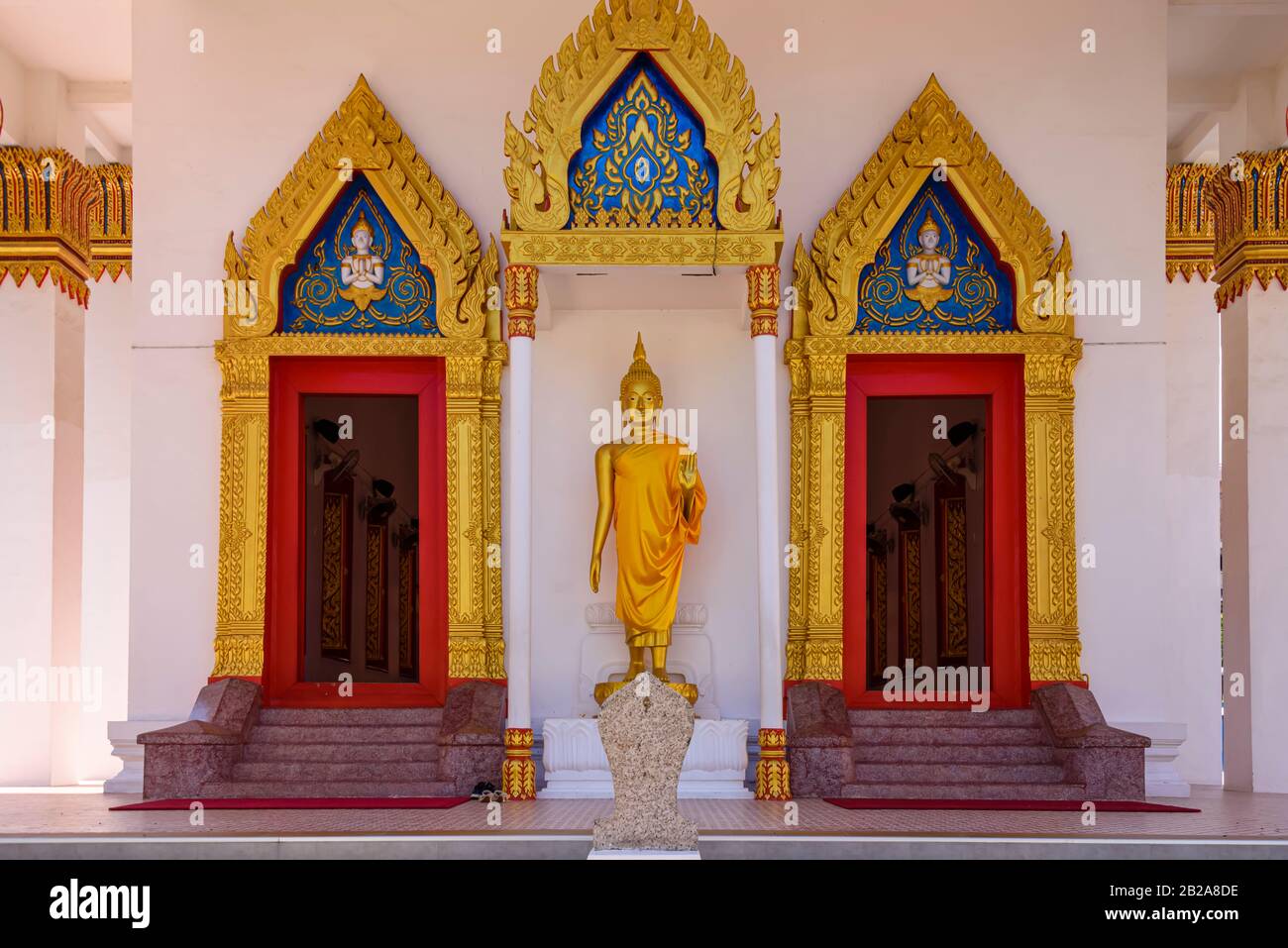 Statue eines goldenen Buddha vor den Türen des buddhistischen Tempels Wat Mongkhon Nimit, Altstadt von Phuket, Thailand Stockfoto