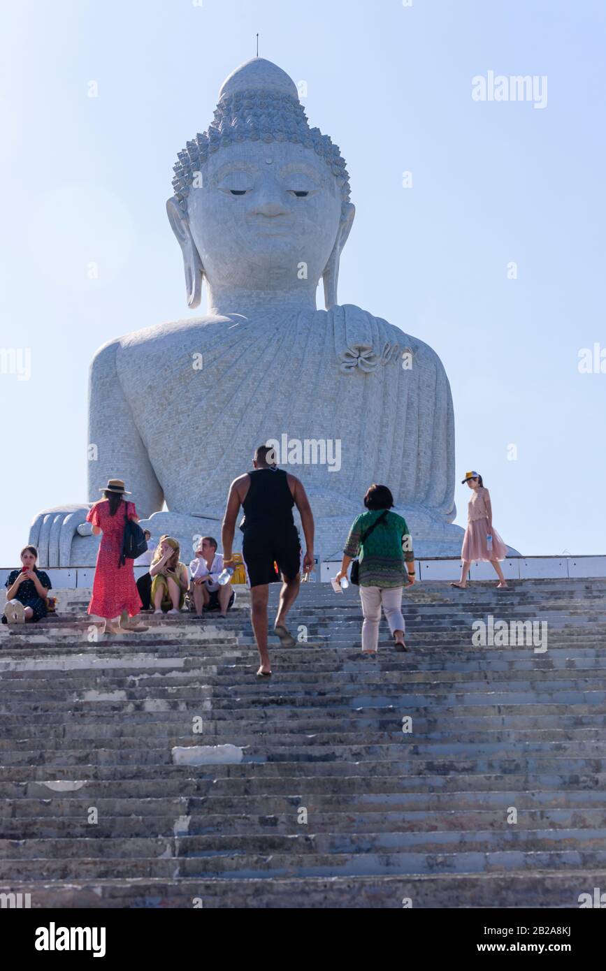 Touristen klettern die Stufen hinauf zum marmorverkleideten Big Buddha oder Zum Großen Buddha von Phuket, einer sitzenden Maravija-Buddha-Statue in Phuket, Thailand. Stockfoto