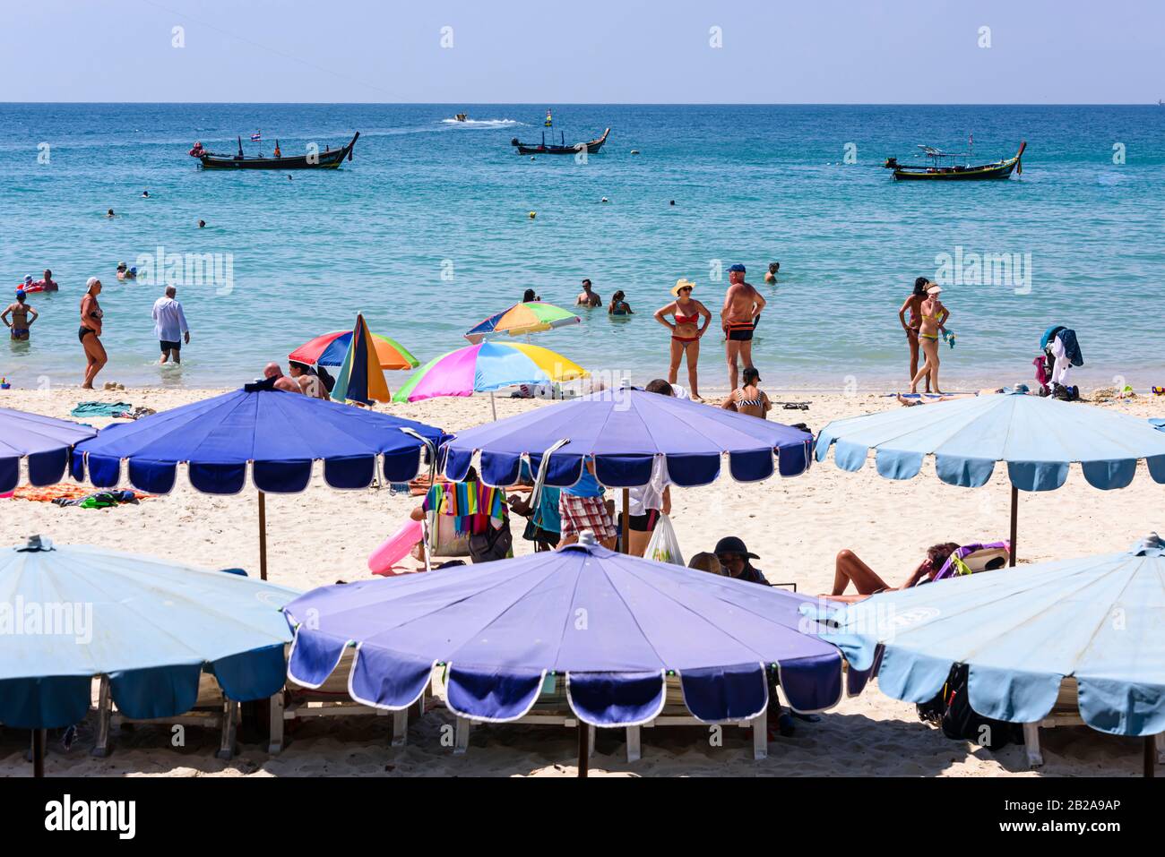 Blaue Sonnenschirme für Touristen am Strand von Kata Beach, Phuket, Thailand Stockfoto