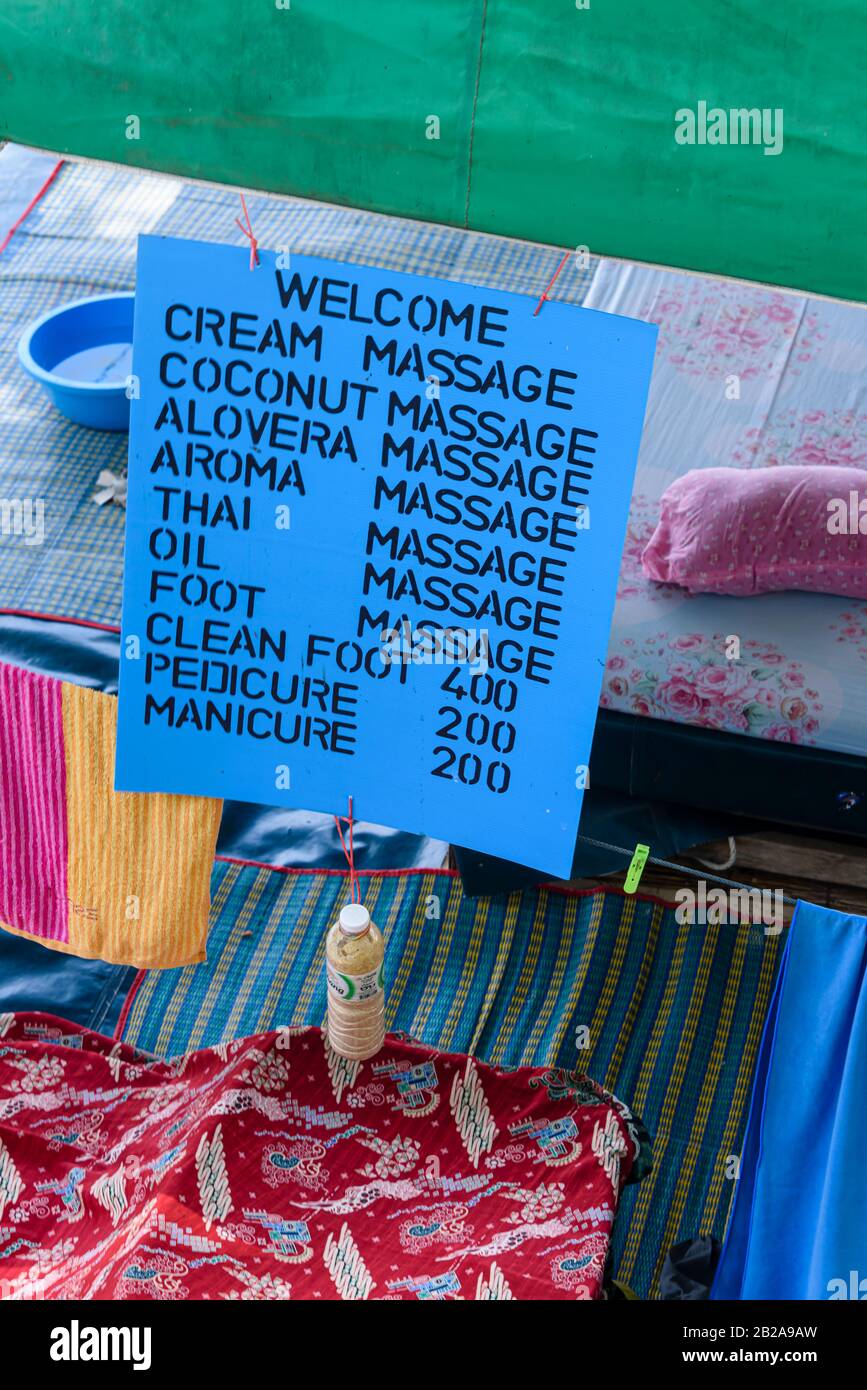 Schild mit verschiedenen Massagearten in einem Thai-Massagesalon, darunter Creme, Kokosnuss, aloevera, Aroma, thai, Öl, Essen, Pediküre und Stockfoto