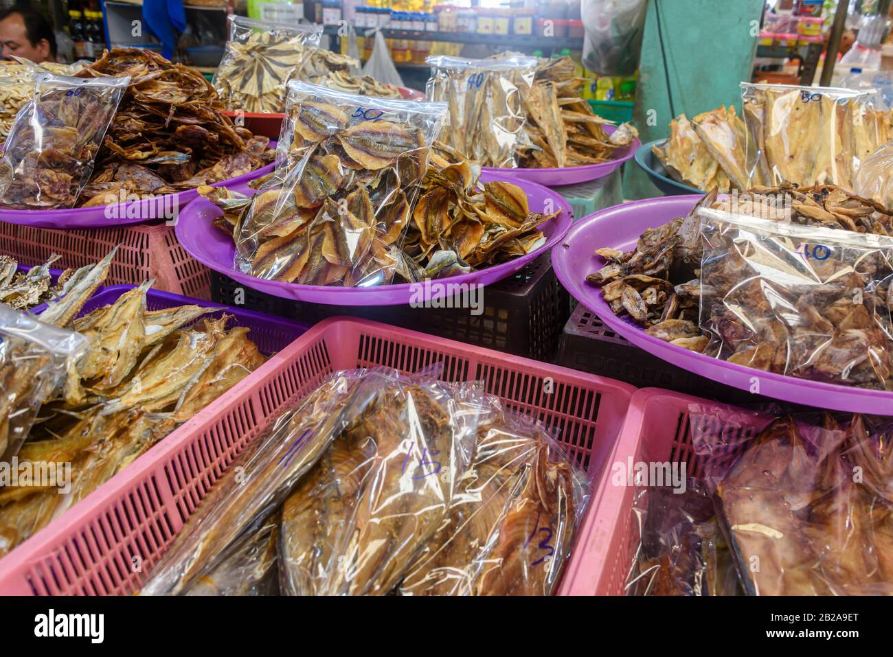 Plastiktüten traditioneller thailändischer Trockenfische, die in einem Lebensmittelmarkt-Stall in Thailand verkauft werden Stockfoto