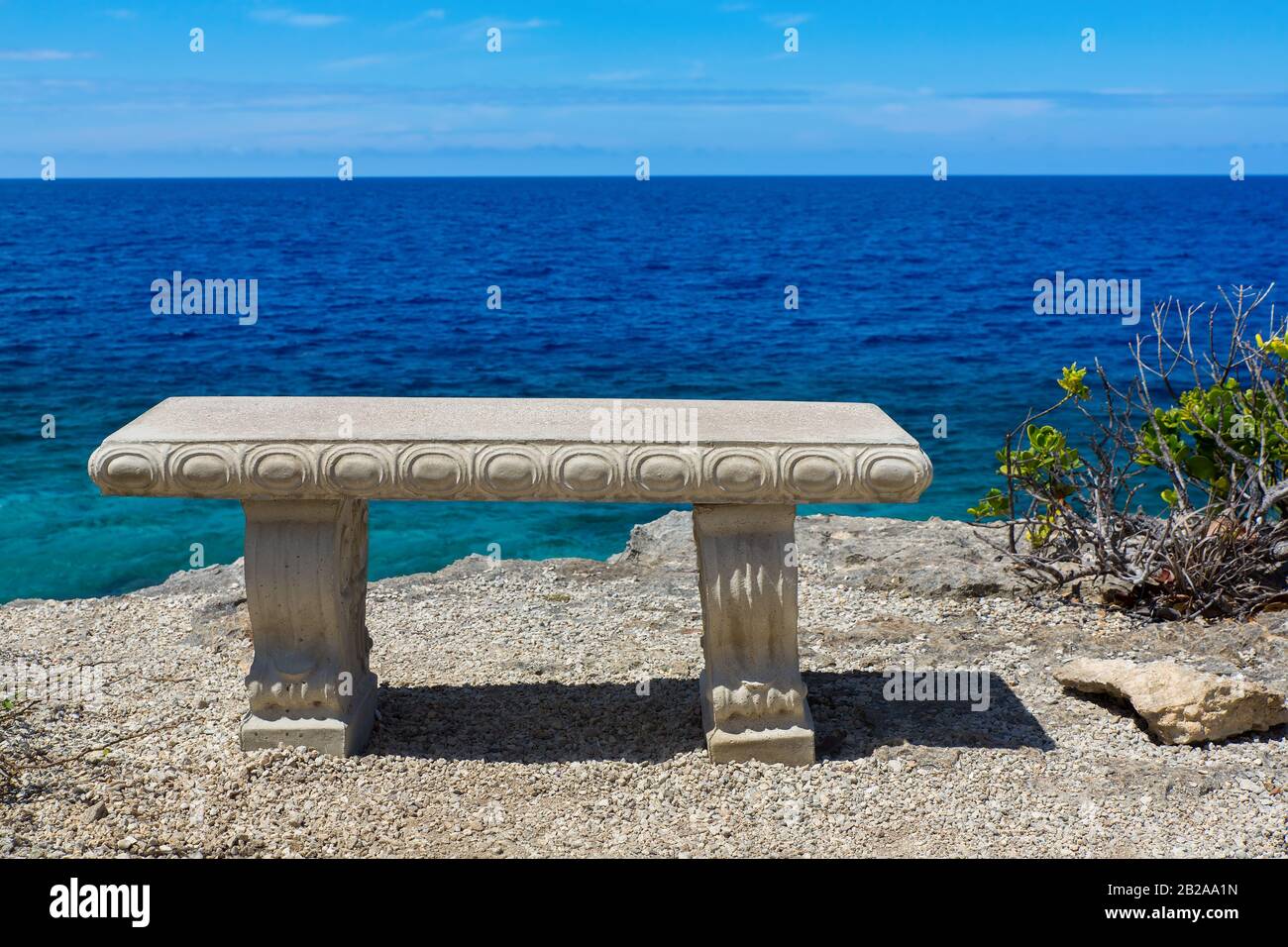 Leere Betonbank am Ufer mit blauem Meer auf der Insel Bonaire Stockfoto