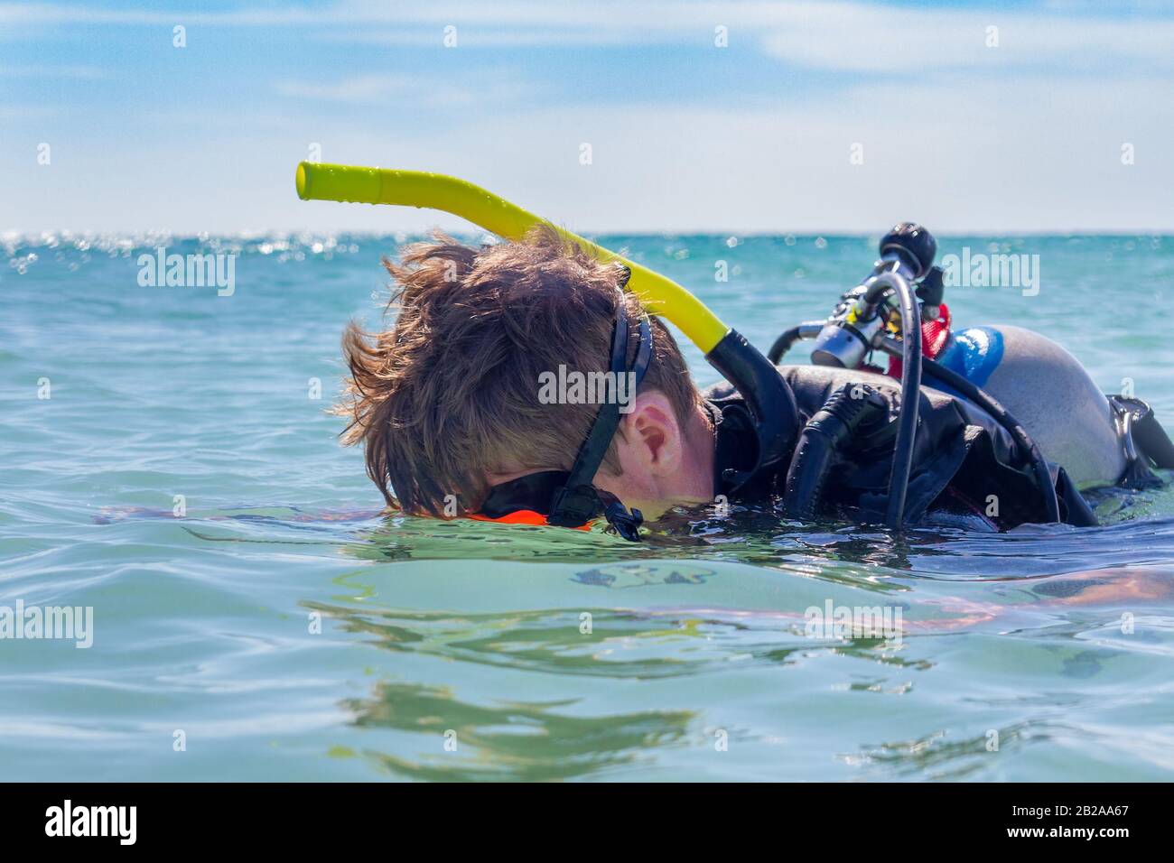 Junger kaukasischer männlicher Taucher blickt im Ozean unter Wasser Stockfoto