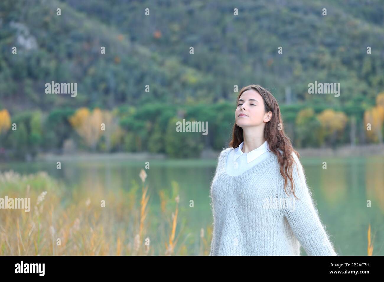 Porträt eines jungen Mädchens, das im Winter frische Luft auf einem See atmet Stockfoto