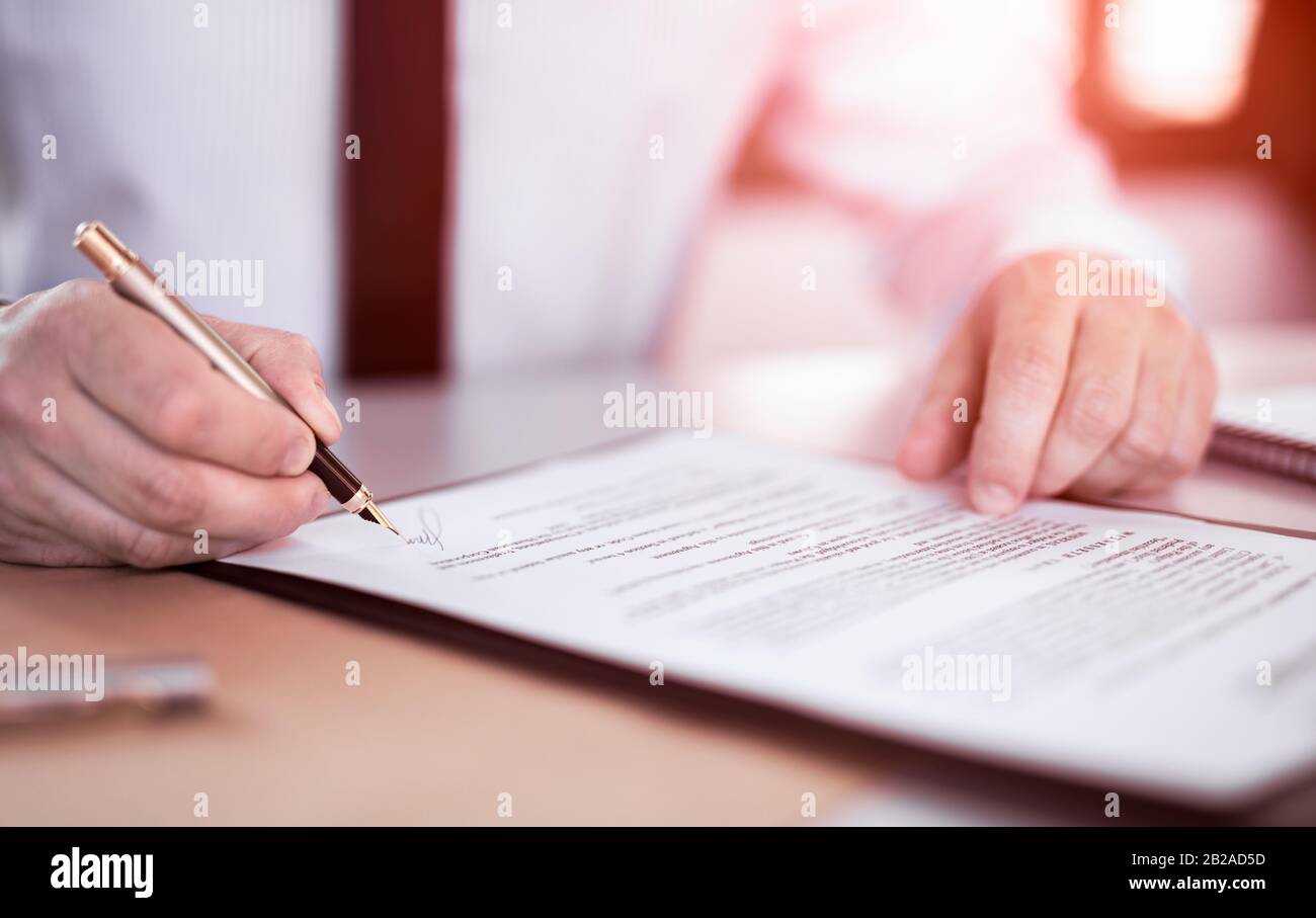 Business man unterschreibt Vertragsdokumente auf dem Büroschreibtisch und macht ein Geschäft. Stockfoto