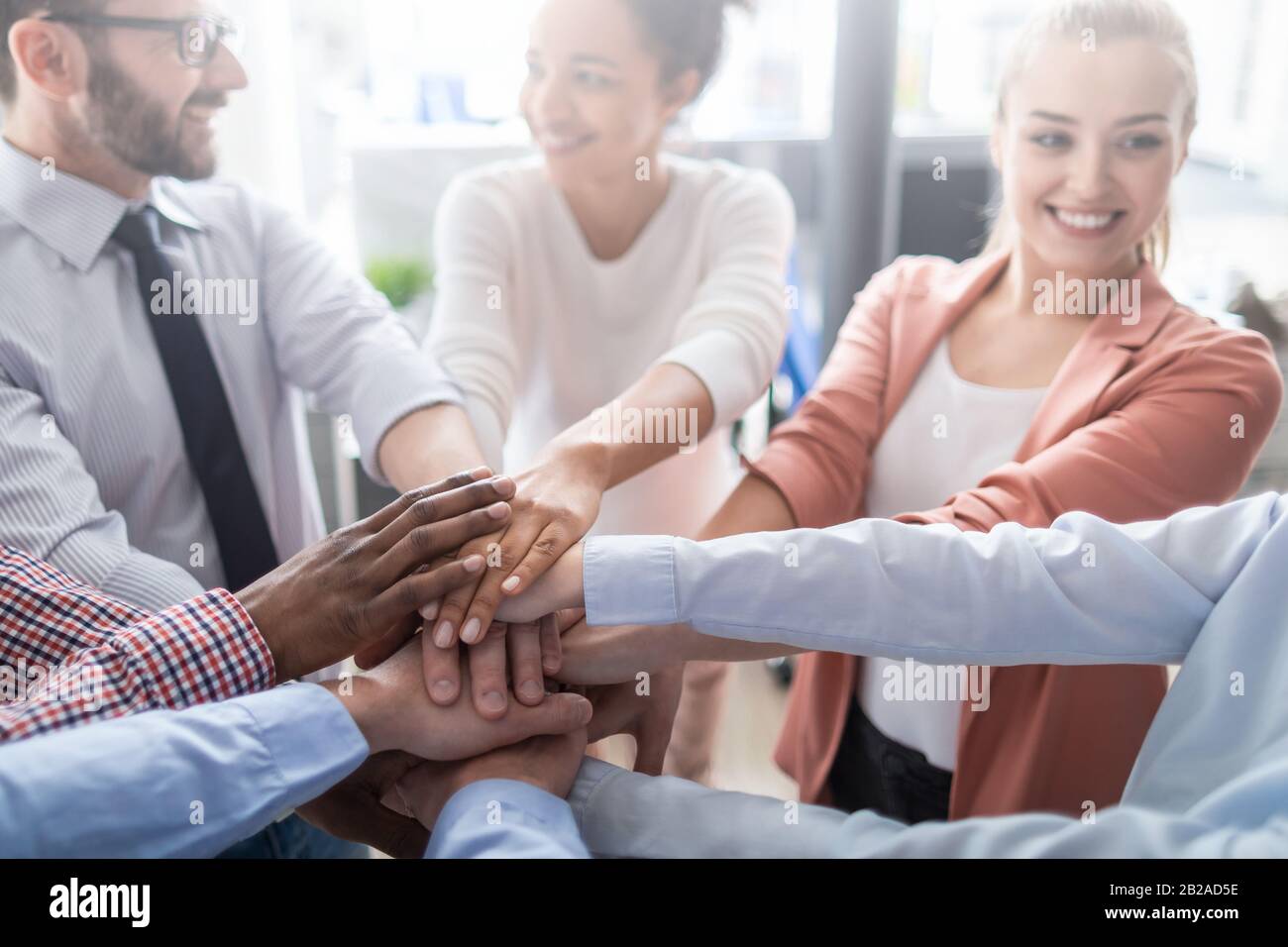 Nahaufnahme der jungen Geschäftsleute, die ihre Hände zusammenlegen. Handstapel. Einigkeit und Teamarbeit. Stockfoto