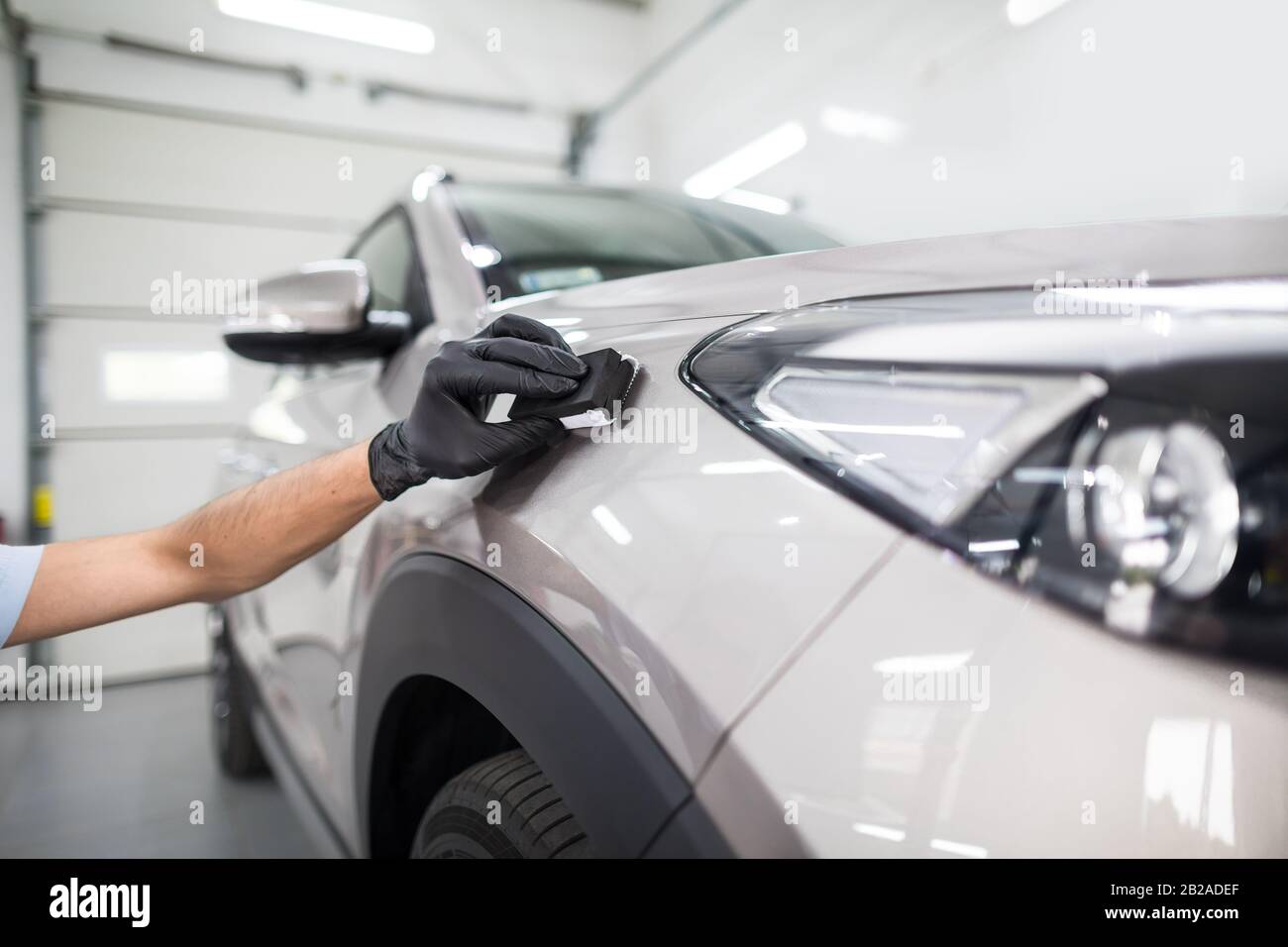 Autodetails - Der Mensch trägt eine Nano-Schutzbeschichtung auf das Auto auf. Selektiver Fokus. Stockfoto