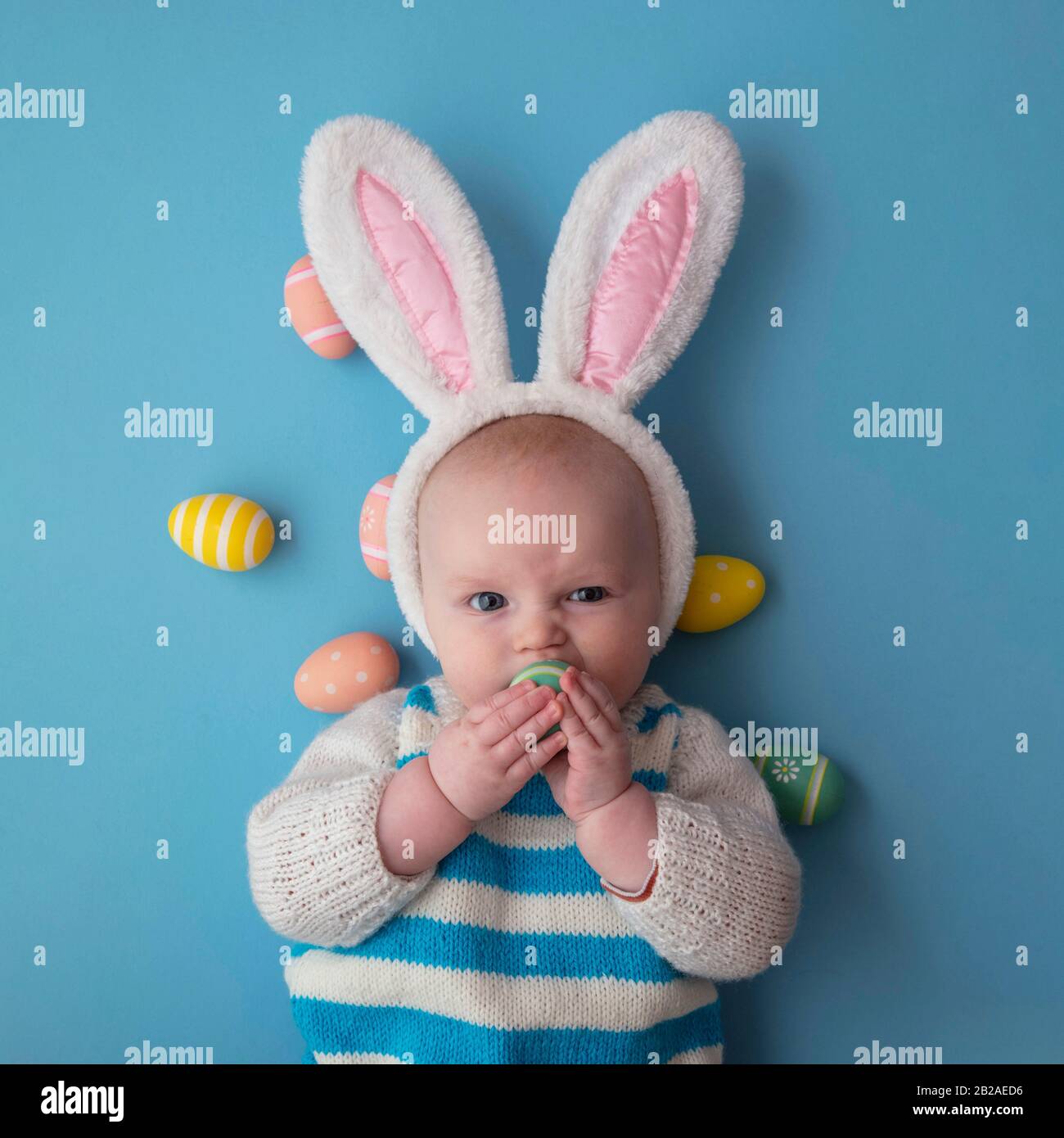 Süßes Baby mit osterbüschen, umgeben von ostereiern. Stockfoto