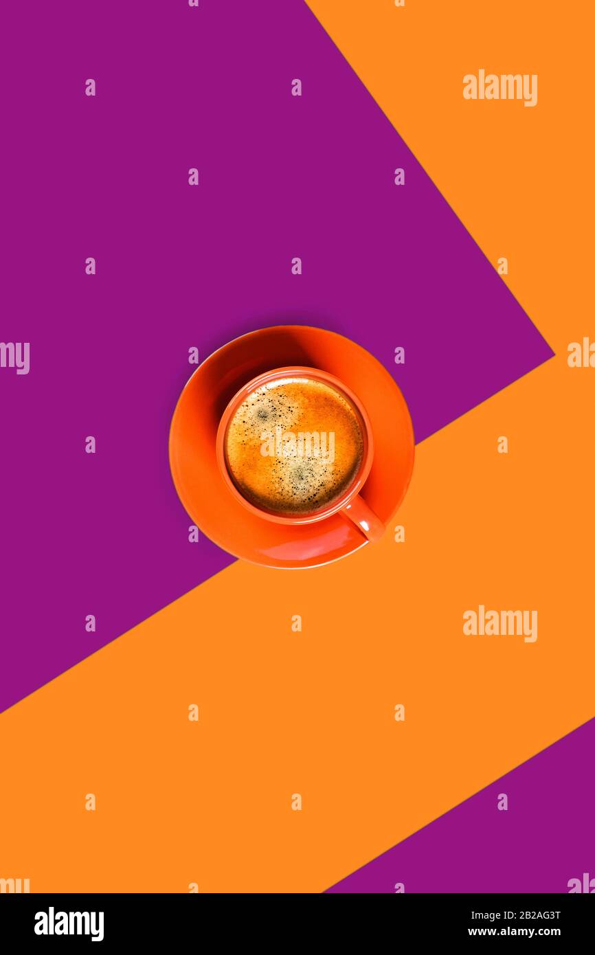Orangefarbener und violetter vertikaler Hintergrund mit einer Tasse leckeren Kaffees. Flaches Layout, Draufsicht, Kopierbereich. Geometrische Zusammensetzung. Stockfoto