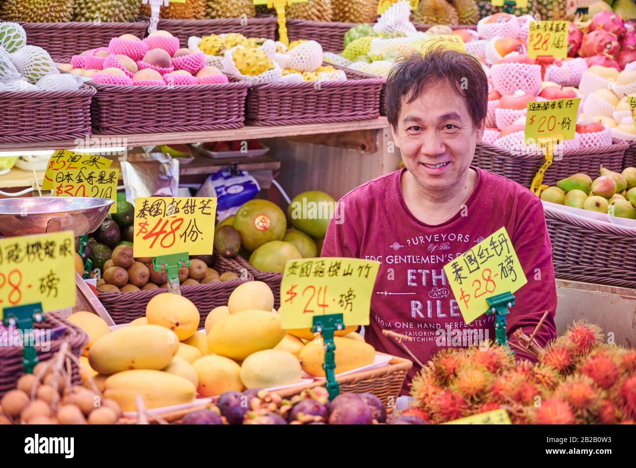 Fruchtseller an seinem Stall, der auf dem Fa Yuan Street Market im Mong Kok District betrieben wird. Hongkong. Stockfoto