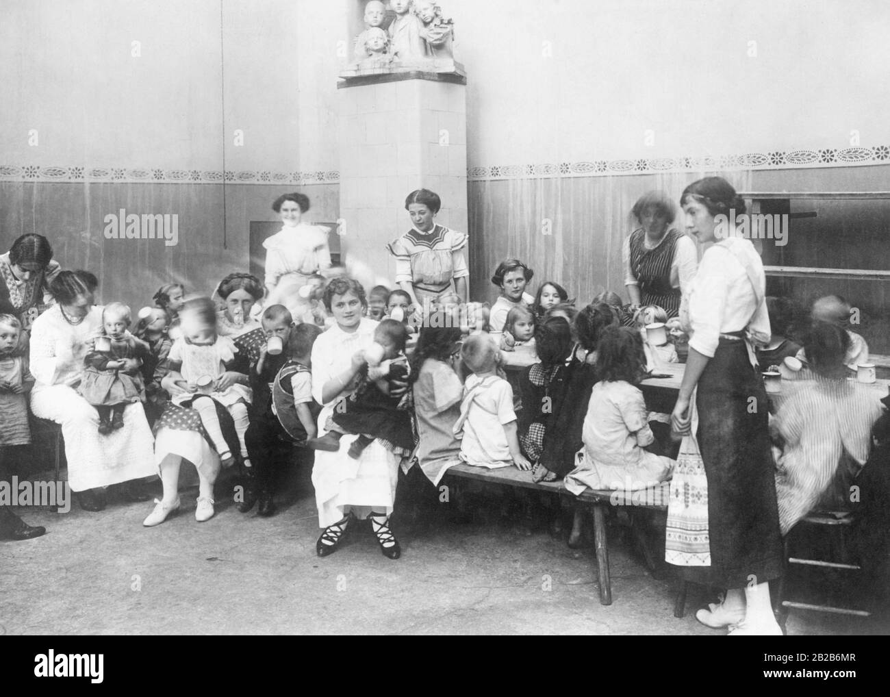 Kindergärtnerinnen und Kindergärtner in einem Kindergarten in Berlin. Diese Kriegskindergärten bieten den Kindern, deren Väter und Mütter arbeiten, Unterkunft und Verpflegung. Stockfoto