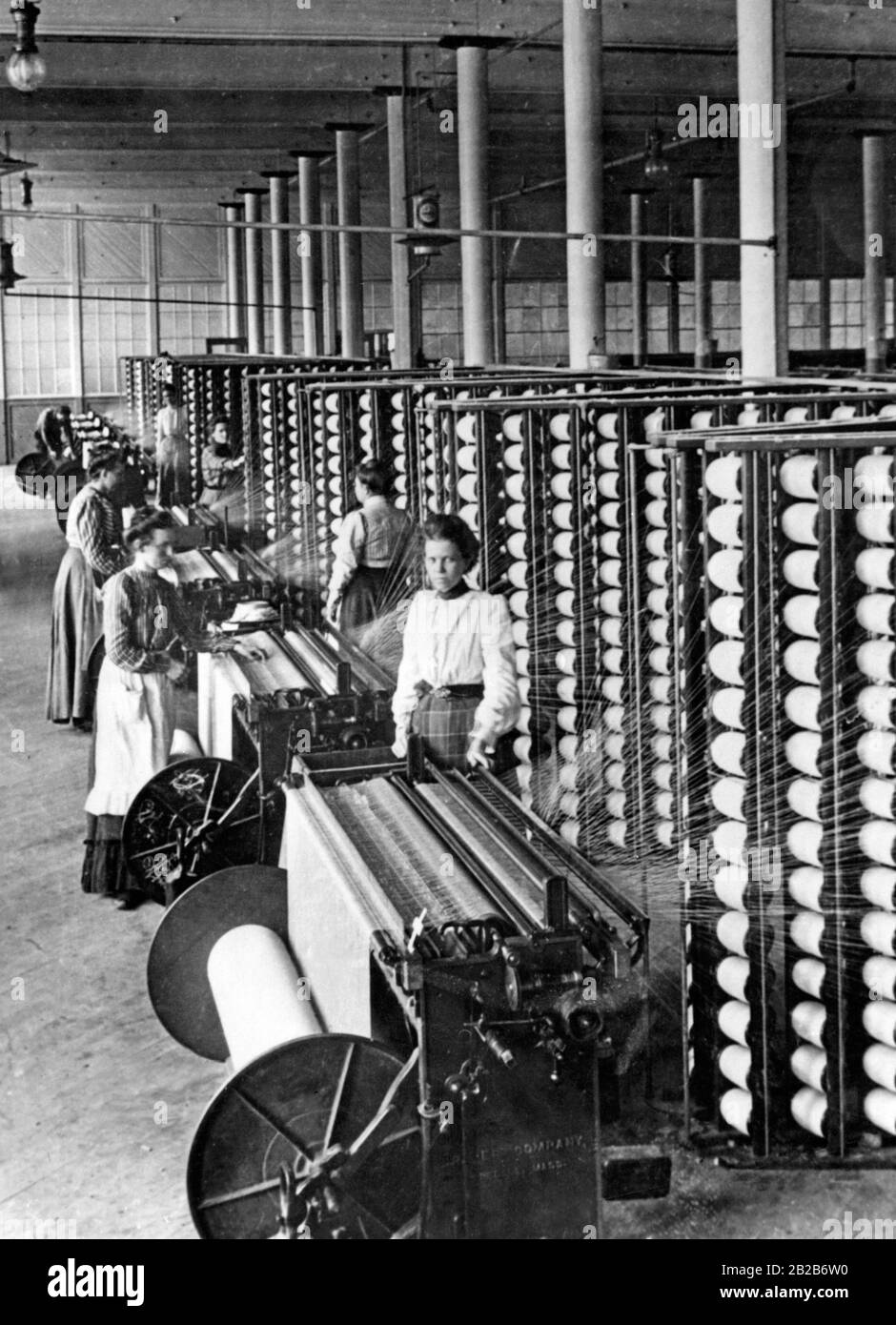 Frauen arbeiten mit Maschinen in einer Baumwollspinnerei Stockfoto
