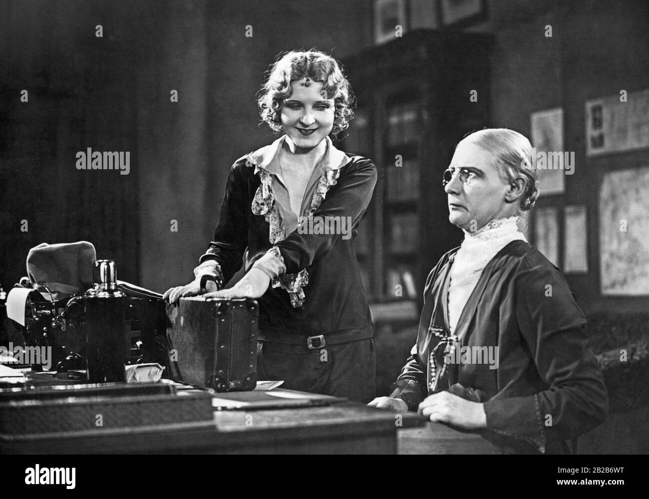 Dieses Bild zeigt eine Szene aus einem Film, in dem ein Büro aus den 1910er Jahren abgebildet ist und Eve Gray einen Büroangestellten porträtiert. Stockfoto