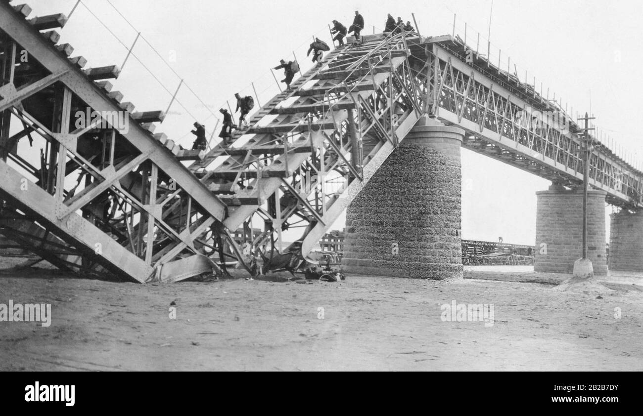 Soldaten, die eine Eisenbahnbrücke über den Hunho-Fluss südlich von Mukden, dem heutigen Shenyang, überqueren, der von russischen Truppen zerstört wurde. Stockfoto