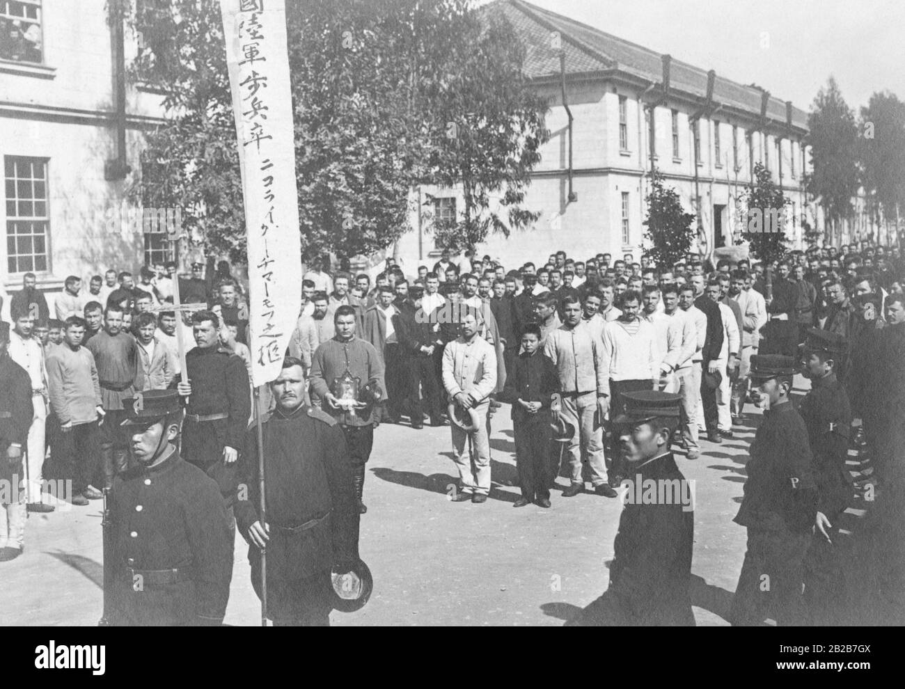 Russische Gefangene nach der Leiche eines verstorbenen Begleiters auf einer Straße in Himeji. Stockfoto
