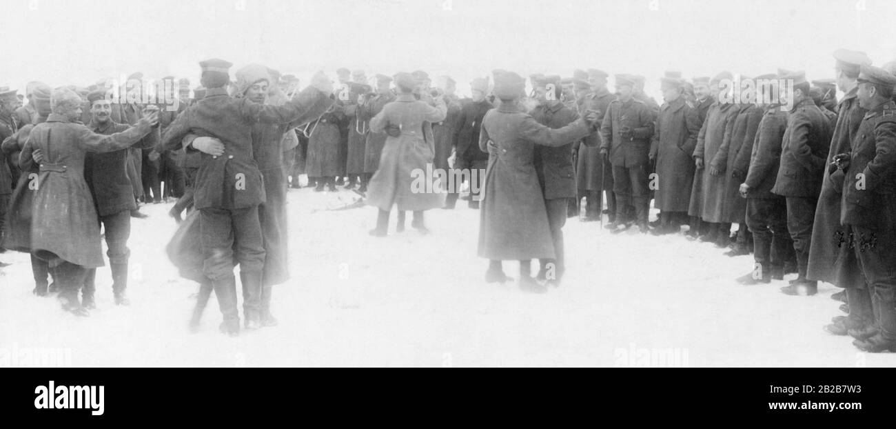 Russische und deutsche Soldaten tanzen gemeinsam an einem Treffpunkt zwischen ihren Positionen, um den Waffenstillstand zu feiern. Stockfoto