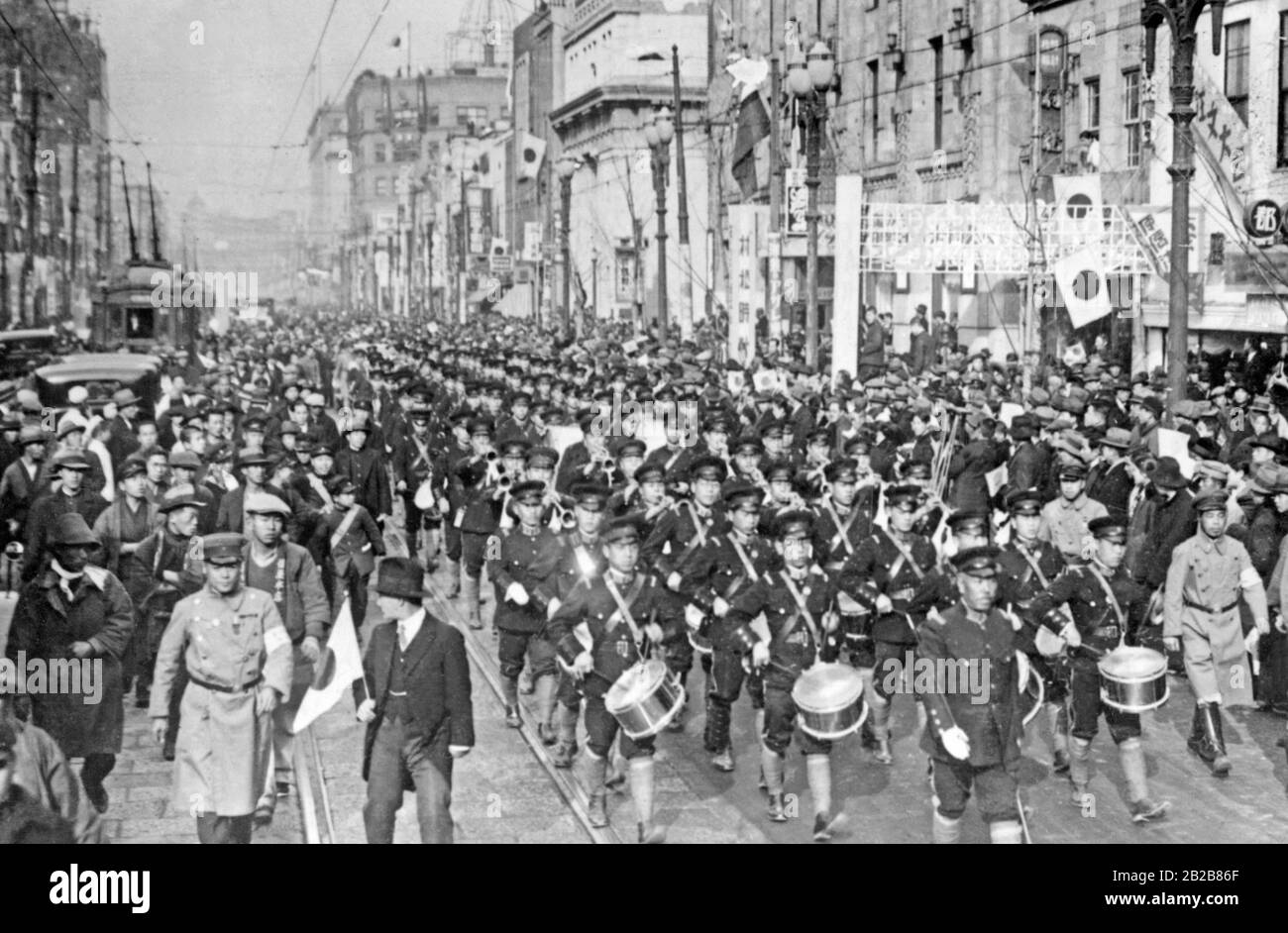 Eine Militärparade in Tokio im Rahmen der Feierlichkeiten zum Tag der japanischen Armee am 10. März 1932, begleitet von Zuschauern aus der Stadt. Stockfoto