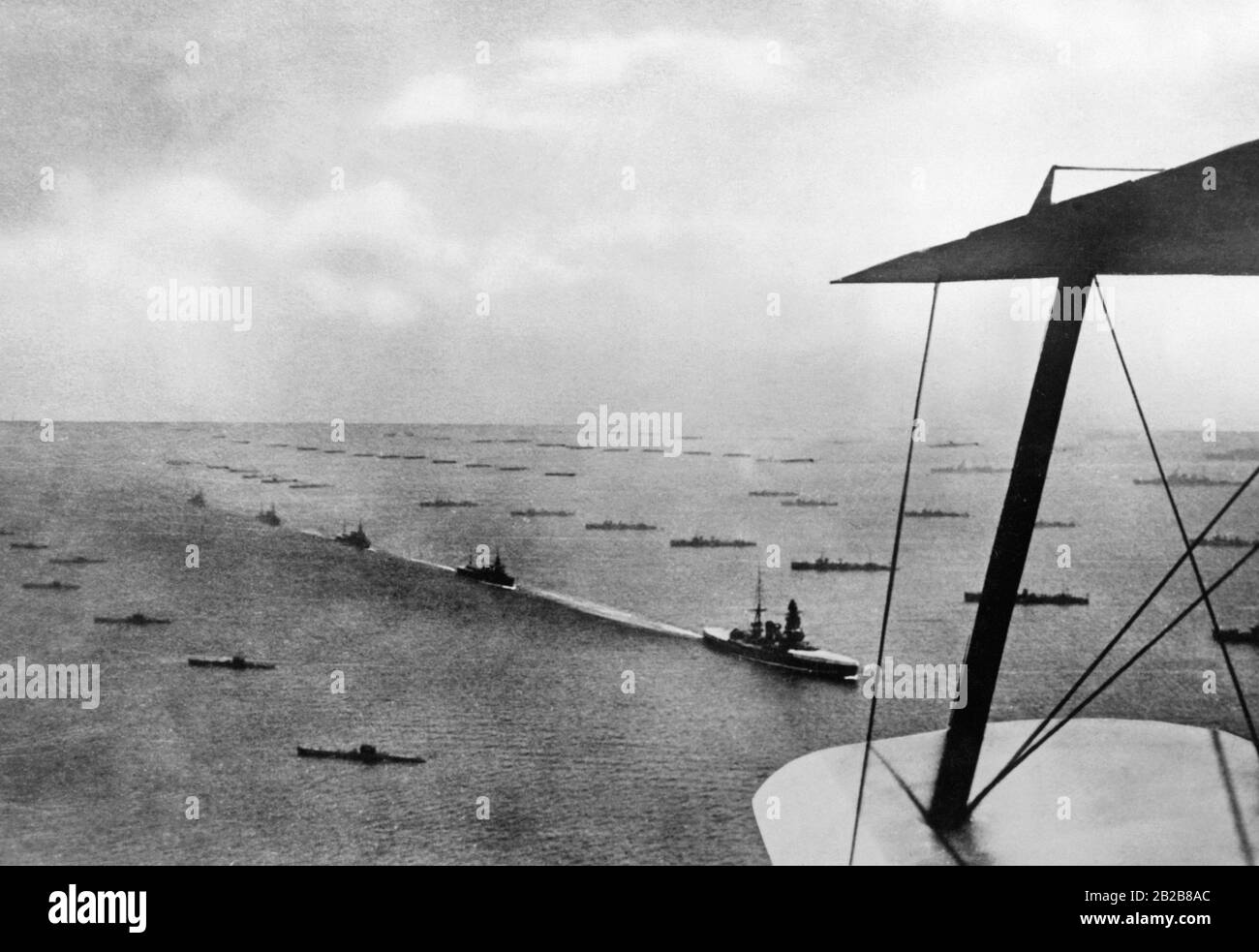 Blick von einem Flugzeug über eine Einheit der Kaiserlich japanischen Marine während einer Parade auf See an der Küste Japans. Zwischen den Schiffsreihen passiert das Schlachtschiff Mutsu, begleitet von mehreren Linienschiffen. Stockfoto