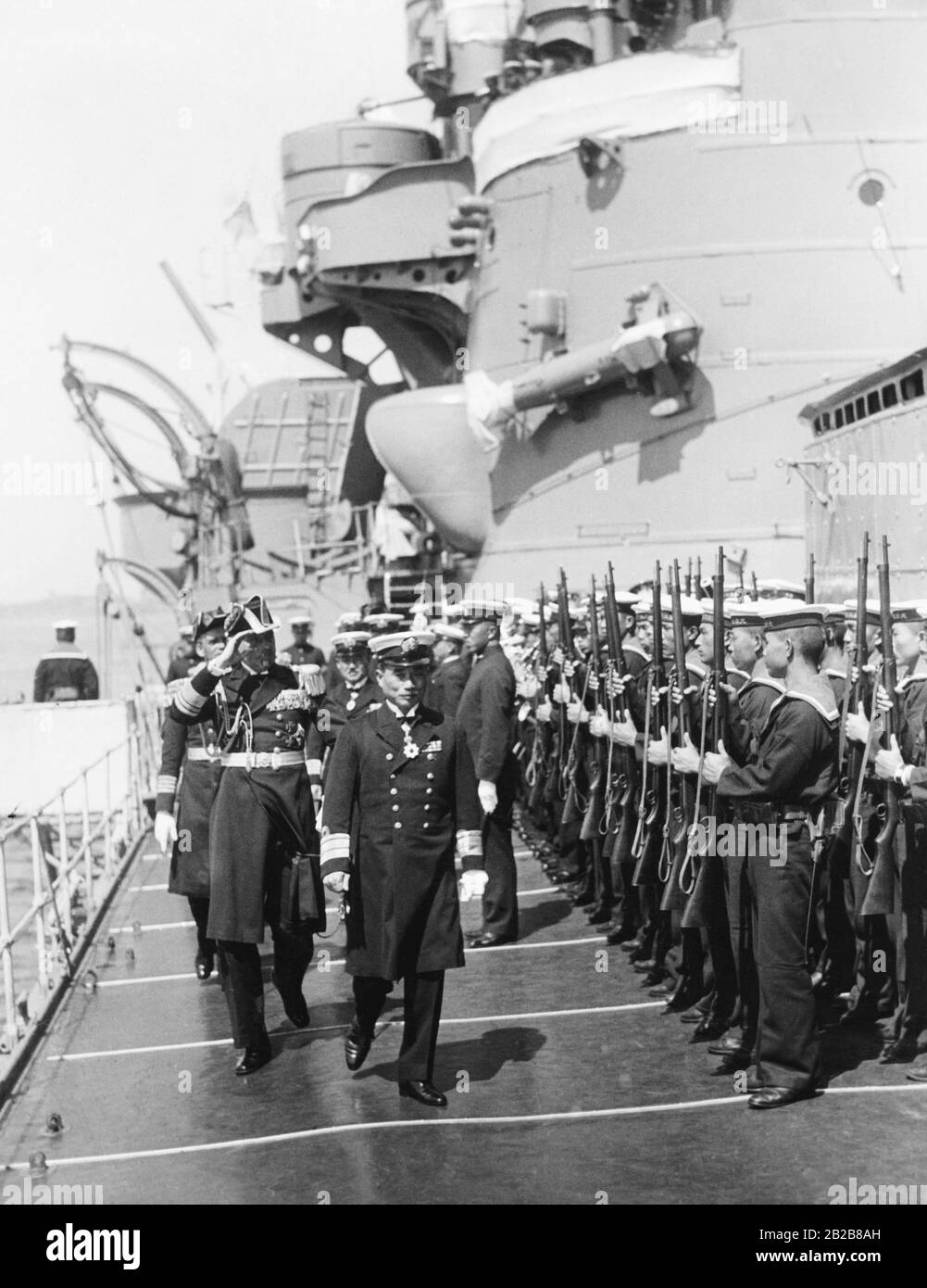 Bei einem Besuch des Kreuzers Ashigara der Kaiserlich japanischen Marine in Kiel inspizieren der deutsche VizeAdmiral Carls und der japanische KonterAdmiral Kobayashi die Besatzung des Schiffes. Stockfoto