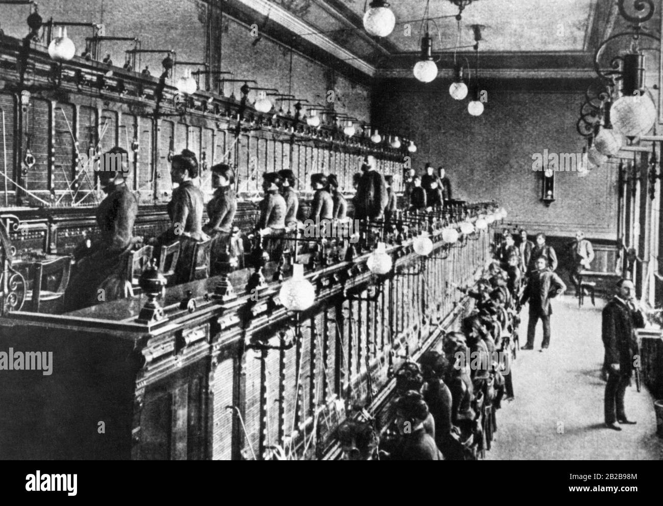 Die erste öffentliche Telefonbörse im Deutschen Reich wurde im Jahr 1881 in Berlin eröffnet. Das Foto zeigt die Telefonzentrale I., in der fast ausschließlich Frauen beschäftigt sind und männliche Postangestellte die Aufseher sind. Stockfoto