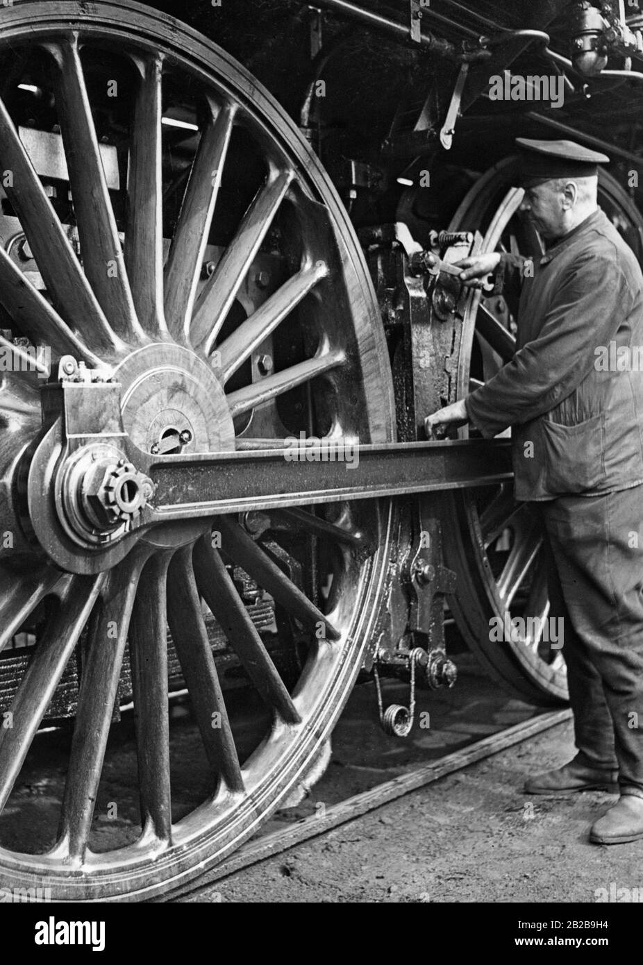 Ein Loktechniker, der die Antriebsräder überprüft. Stockfoto