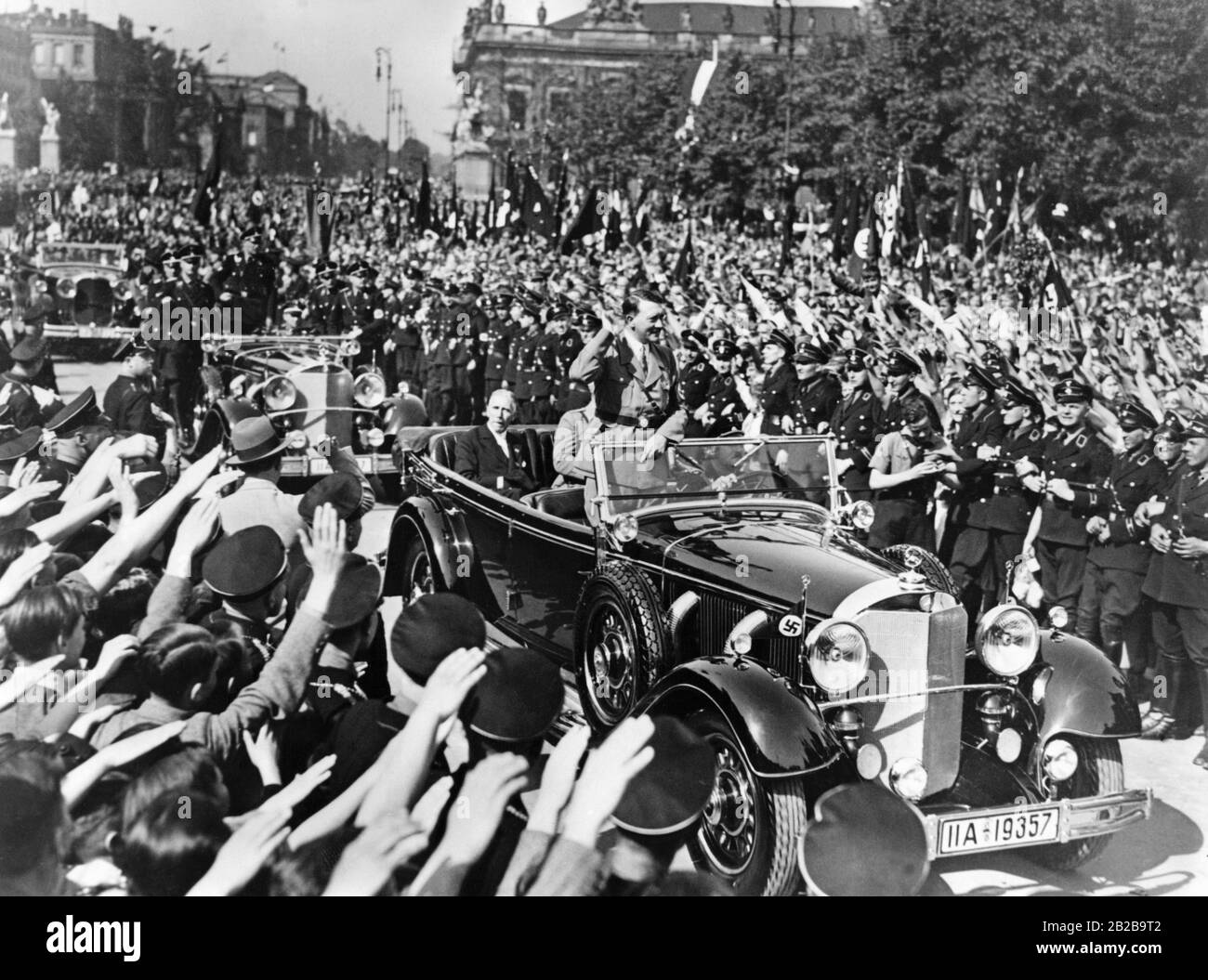 Wiener Bürger jubeln den NS-Funktionären Adolf Hitler und Franz von Papen bei ihrer Fahrt durch Wien, hier an der Ringstraße, zu. Stockfoto