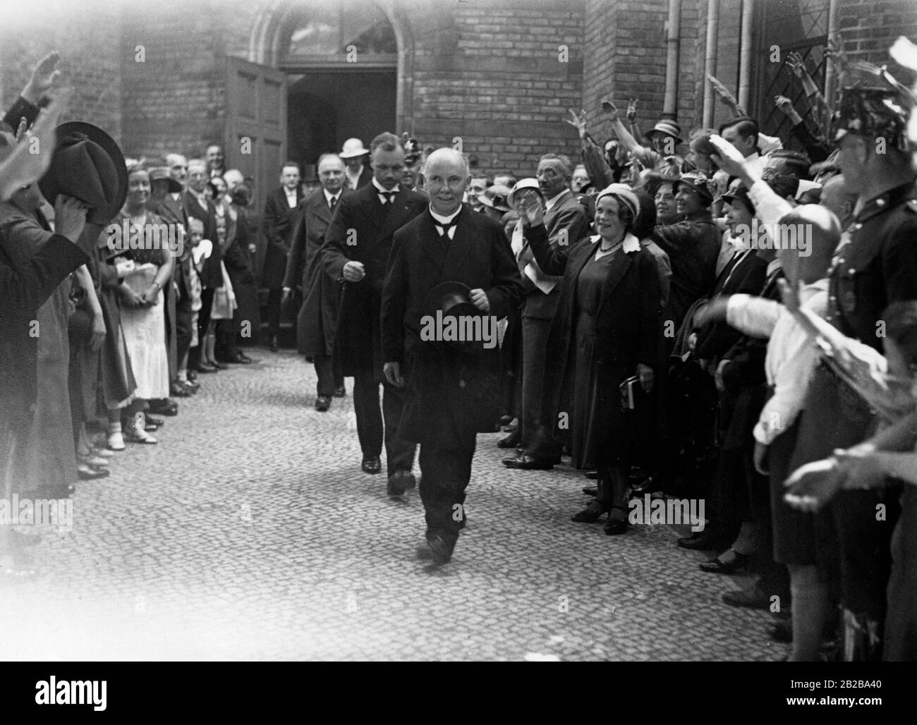 Nach einem Gottesdienst an der Zionskirche am pfingsten 1933 verlässt der Bischof Bodelschwingh die Kirche und wird von der wartenden Menge mit dem Nazi-Salut begrüßt. Stockfoto