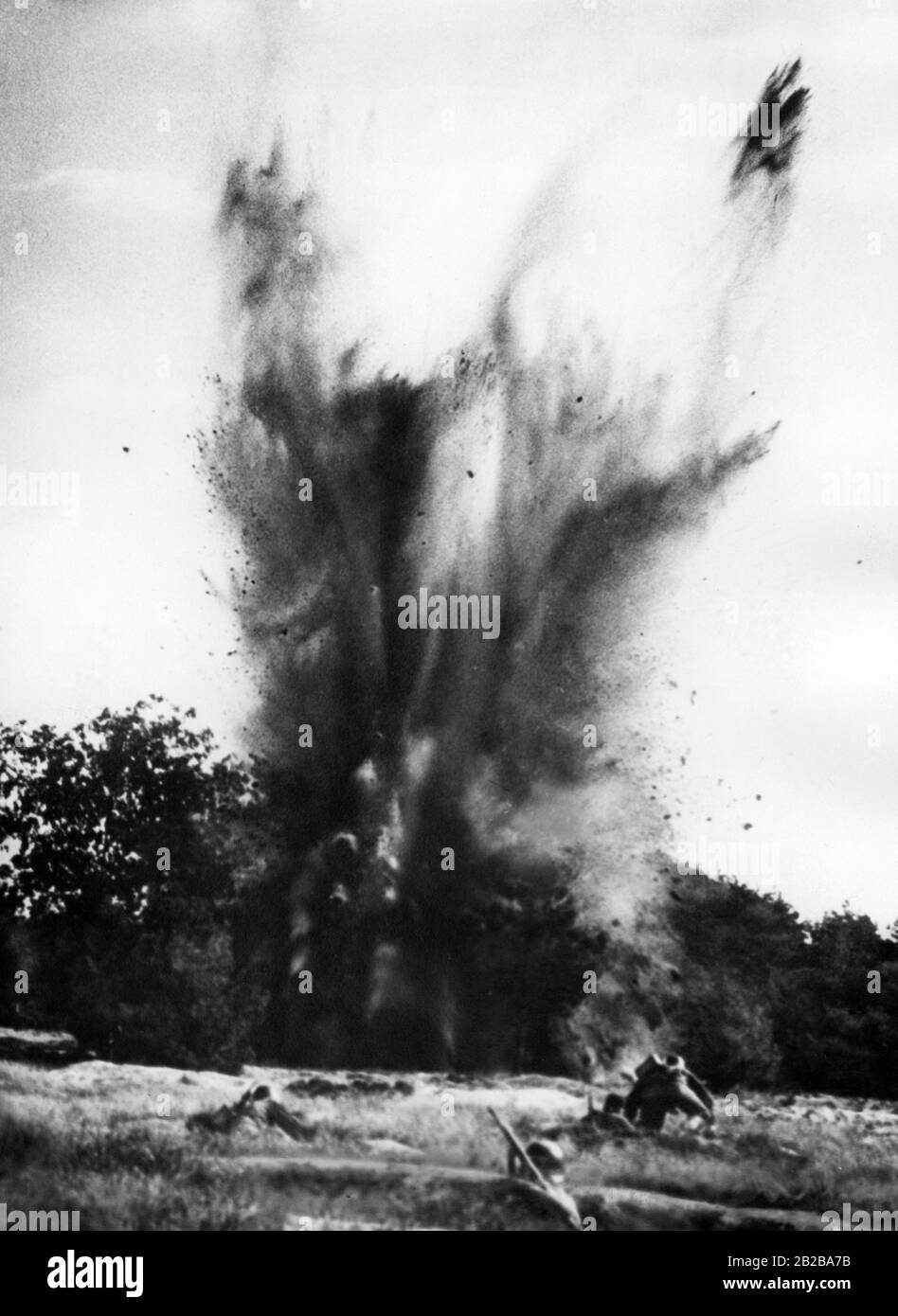 Deutsche Soldaten vor einem französischen Bunker der Maginot-Linie, der bekämpft werden soll. Explosion einer Sprengladung. Stockfoto