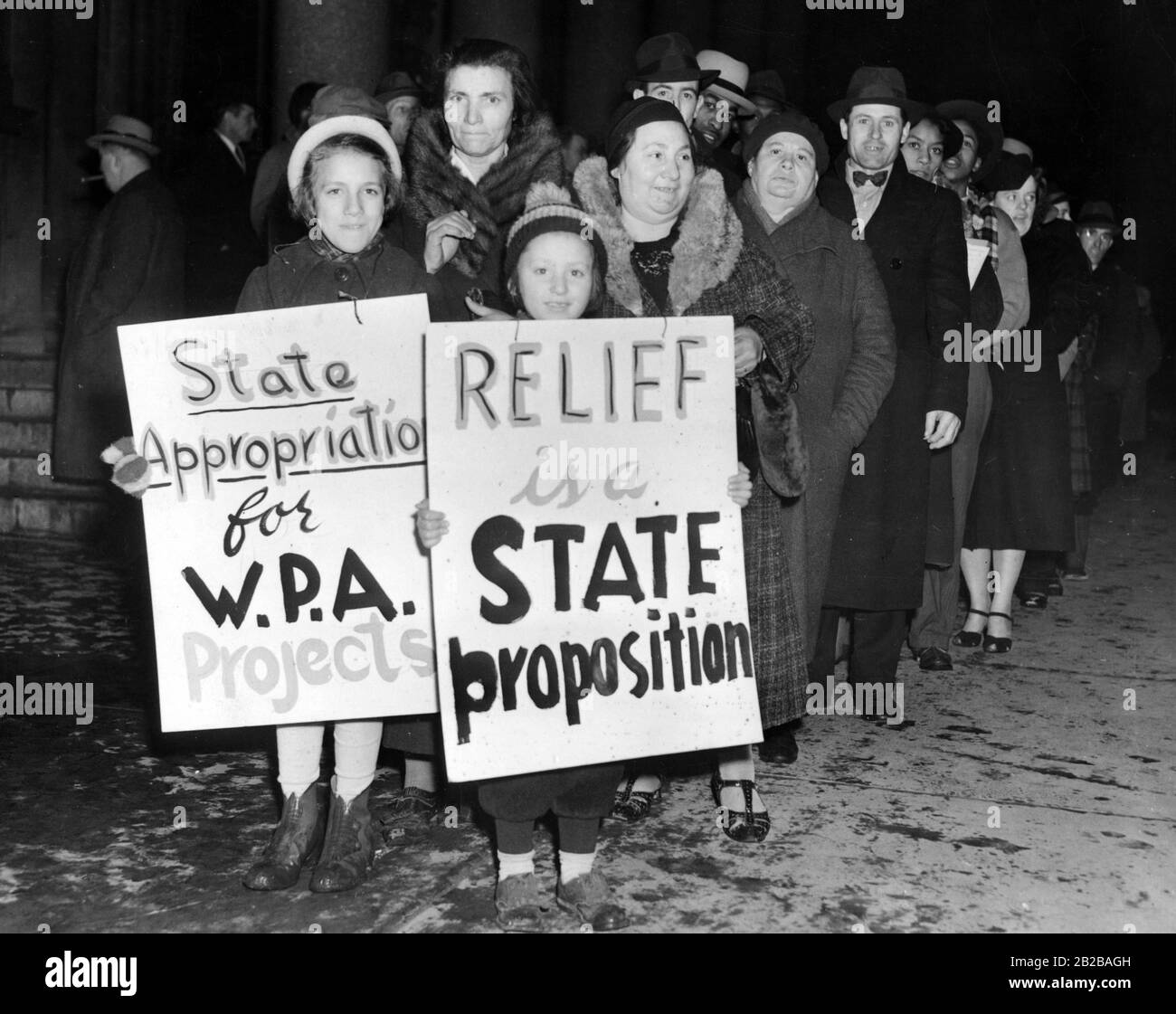 Kinder mit Bannern für die Reformen des New Deal: "Mittel für W.P.A-Projekte aneignen", "Erleichterung ist ein Staatsvorschlag". Stockfoto