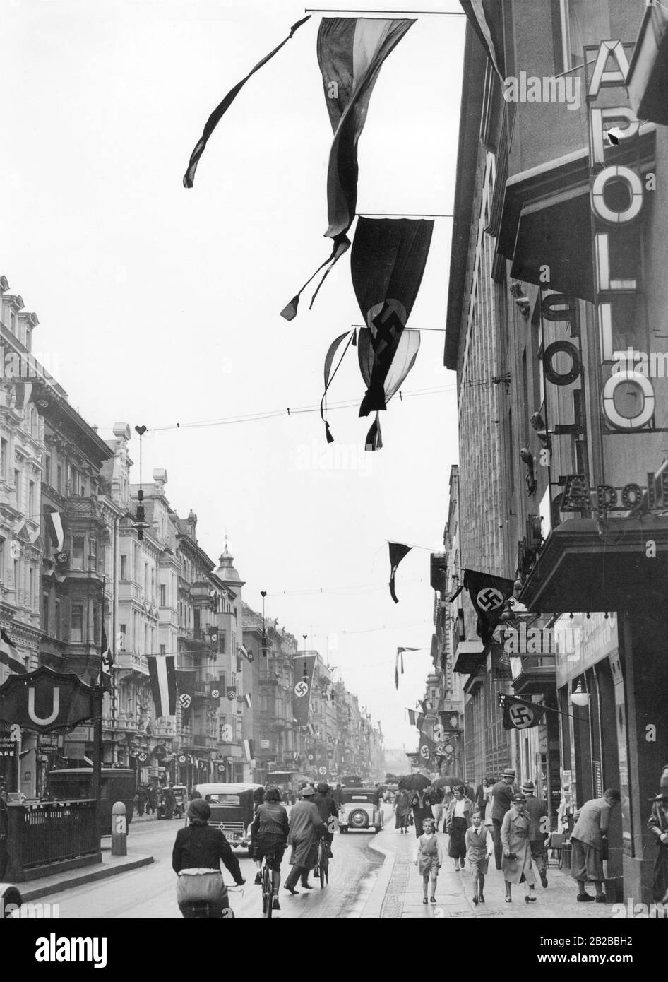 Schwenkende Reichs-Flaggen und Hakenkreuzfahnen, die 1933 durch ein Dekret von Reichspräsident Paul von Hindenburgs als gemeinsame Nationalflaggen eingeführt wurden, an der Berliner Friedrichstraße. Stockfoto