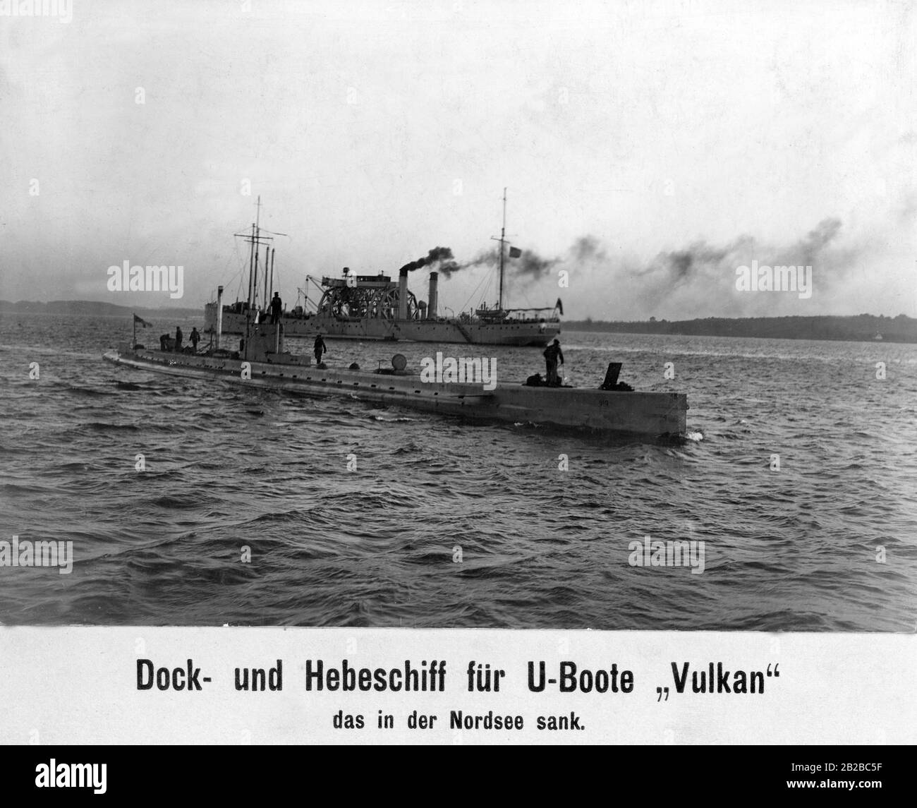 Bild des Dock- und Hubschiffs "Vulkan", das später in der Nordsee sank. Im Vordergrund steht ein U-Boot. Das Dockschiff ist ein doppeltes Schiff und gehört zum Typ des U-Boot-Bergungsschlegs. Sie wurde unter anderem zur Reparatur von U-Booten eingesetzt. Stockfoto