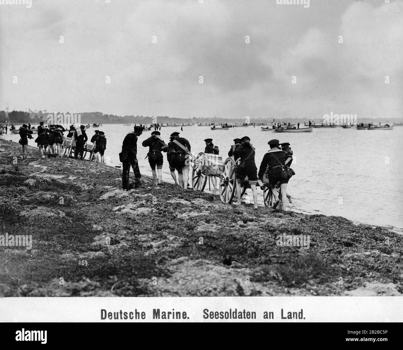 Deutsche Marineinfanteristen an Land. Am Strand ziehen sie einen Wagen mit Ausrüstung und Kisten. Stockfoto