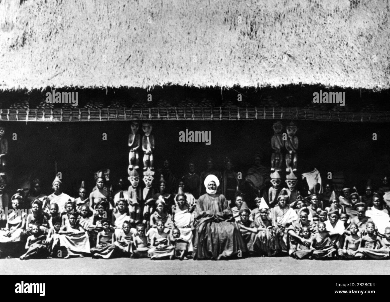 Der König des neu entdeckten Landes, die jetzt deutsche Kolonie Kamerun, umgeben von den Frauen seines Harems und einigen Kindern im Hof seines Palastes. Undatiertes Bild. Stockfoto