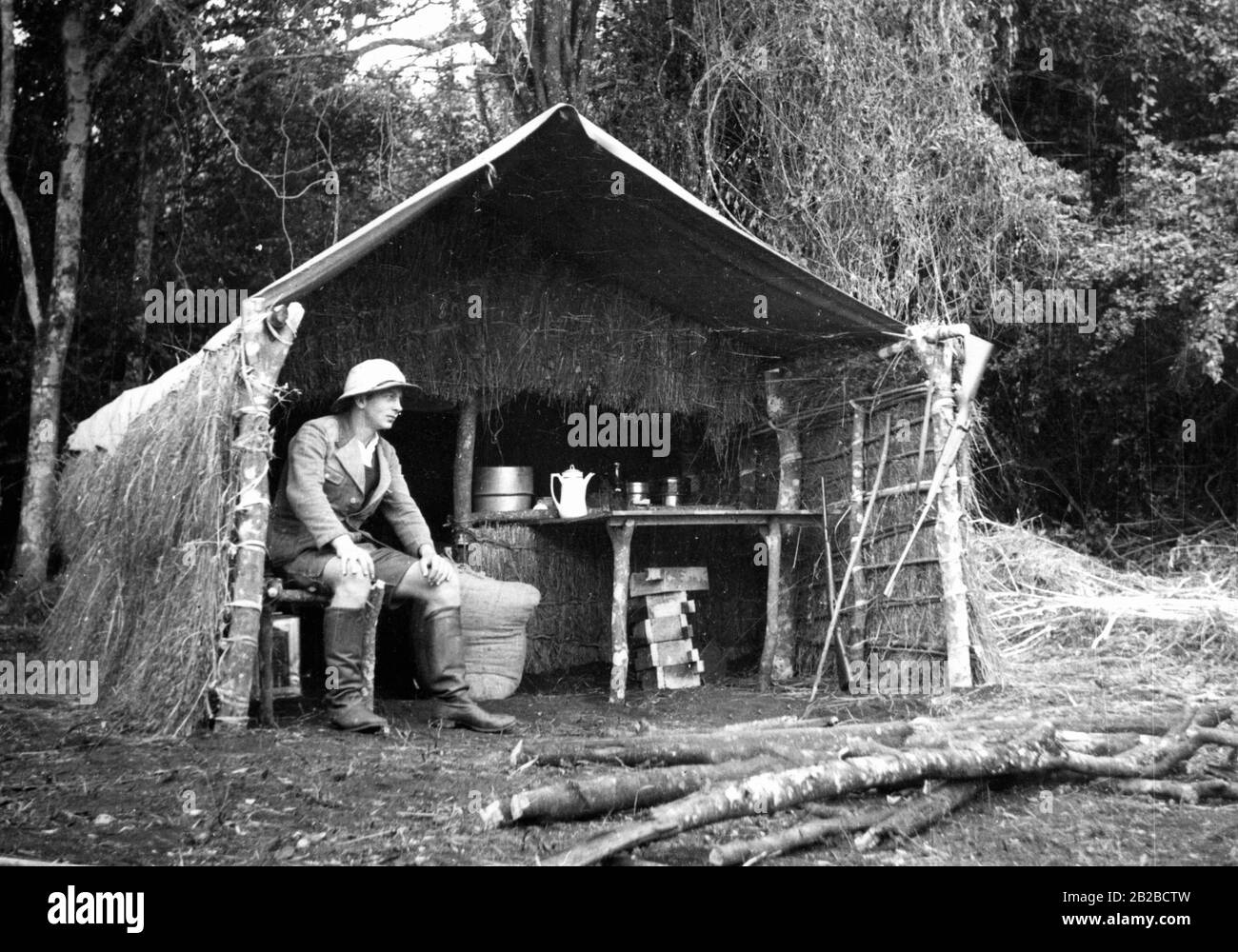 Ein deutscher Soldat sitzt in einer Grashütte in Oldeani im deutschen Ostafrika. Das Bild entstand zu Beginn der deutschen Kolonialzeit und die Hütte war die erste Befestigungsanlage, die von den deutschen Soldaten nach ihrer Ankunft errichtet wurde. Undatiertes Foto. Stockfoto