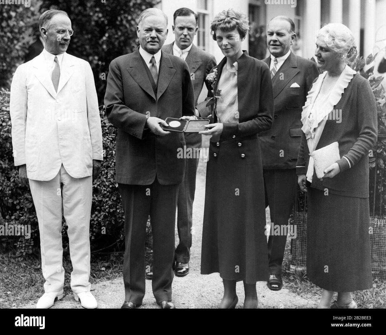 Amelia Earhart erhält für ihren Transatlantikflug eine Goldmedaille von J. Edgar Hoover. Mit ihr im Weißen Haus sind (von links nach rechts): Dr. Gilbert Grosvenor, Präsident Hoover, George Palmer Putnam, Amelia Earhart, John O. La Gorce und Mrs Hoover. Stockfoto