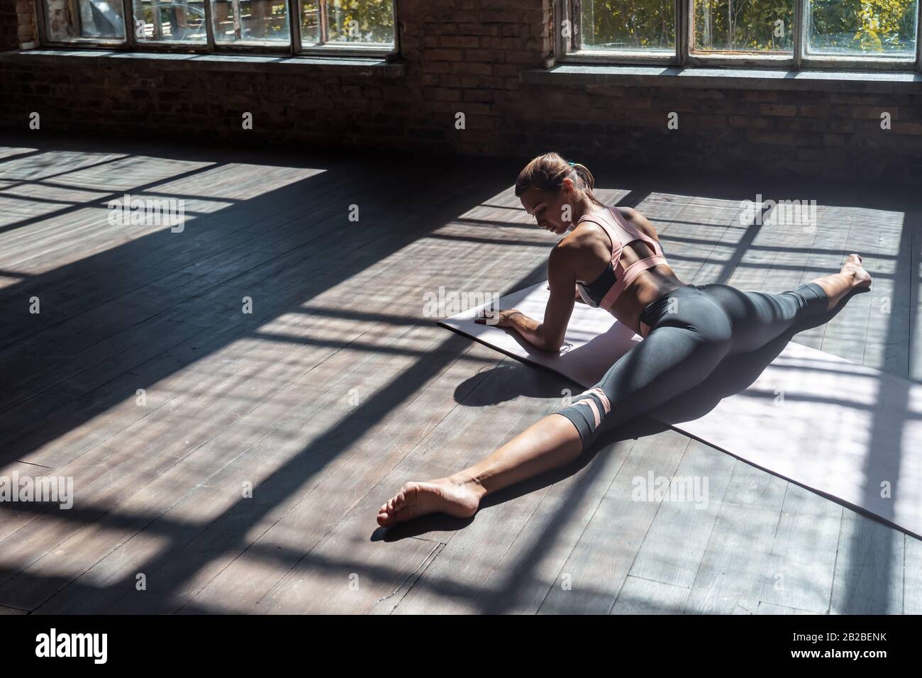 Junge sportliche Mädchen üben Hatha Yoga weit spaltet Haltung gesunde Lebensweise. Stockfoto