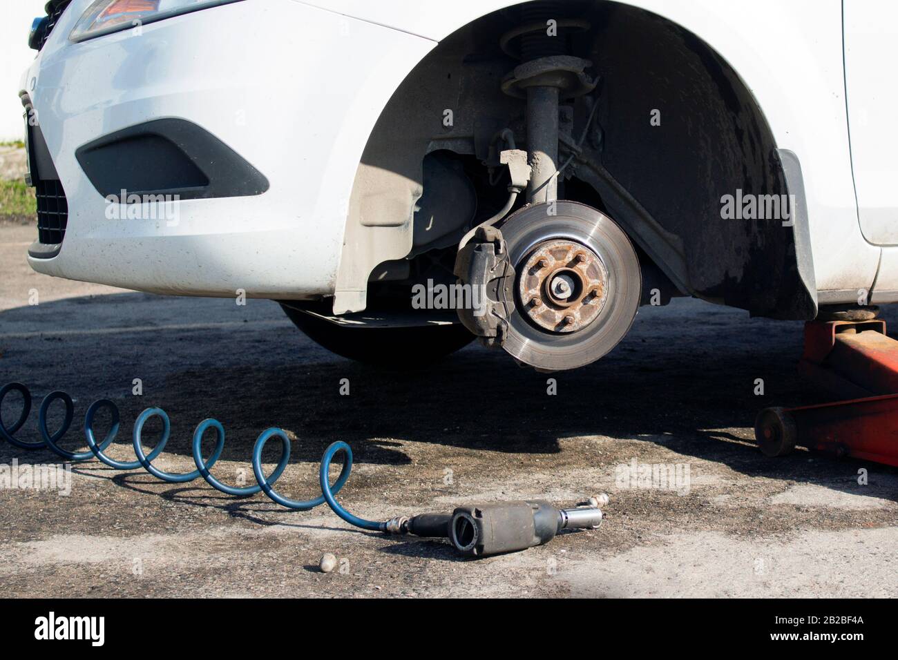 Auto ohne Rad und mit Hydraulik anheben, warten auf Reifenwechsel  Stockfotografie - Alamy