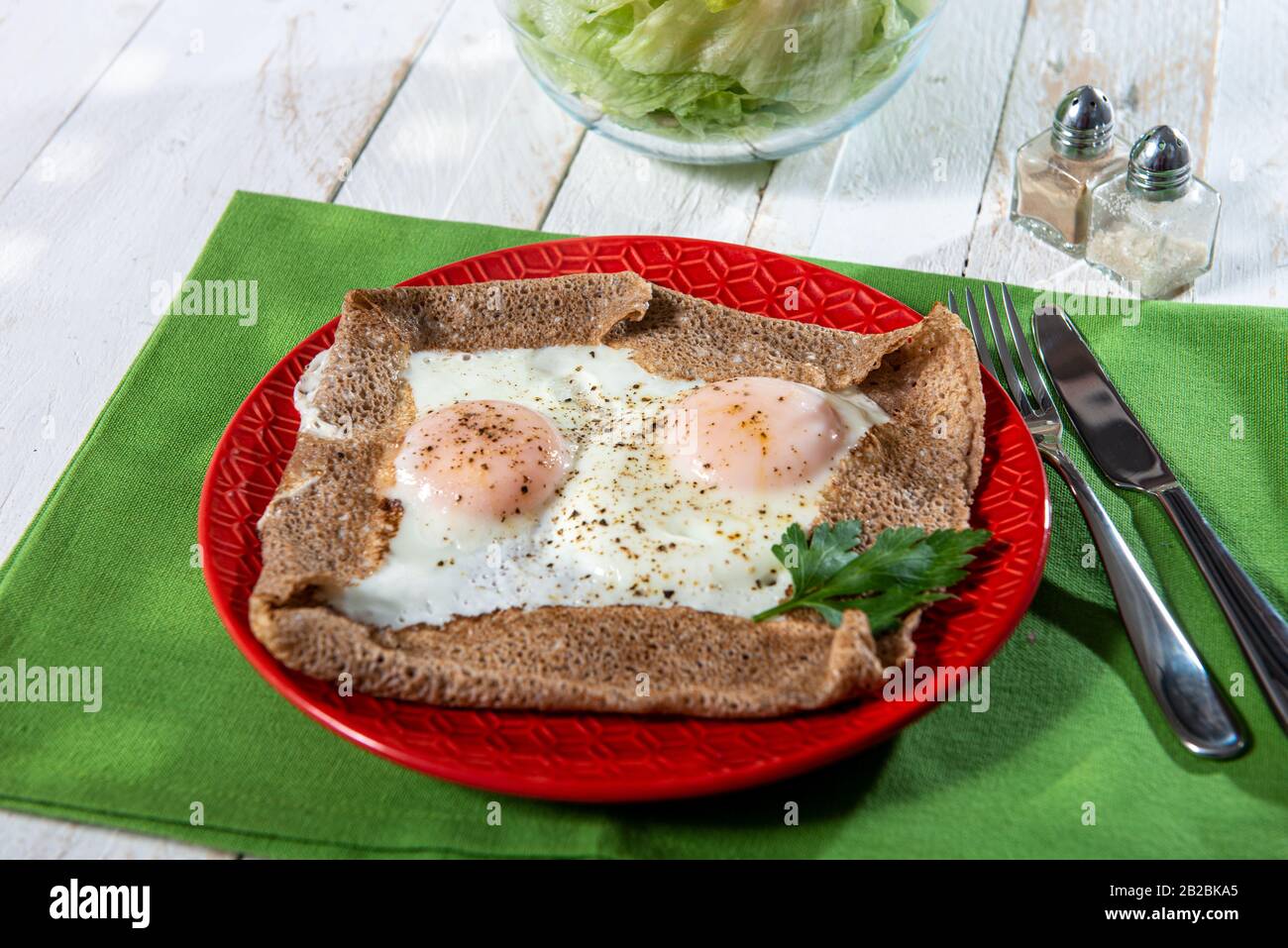 Hausgemachte bretonische Kreppe mit Ei in einem roten Teller Stockfoto