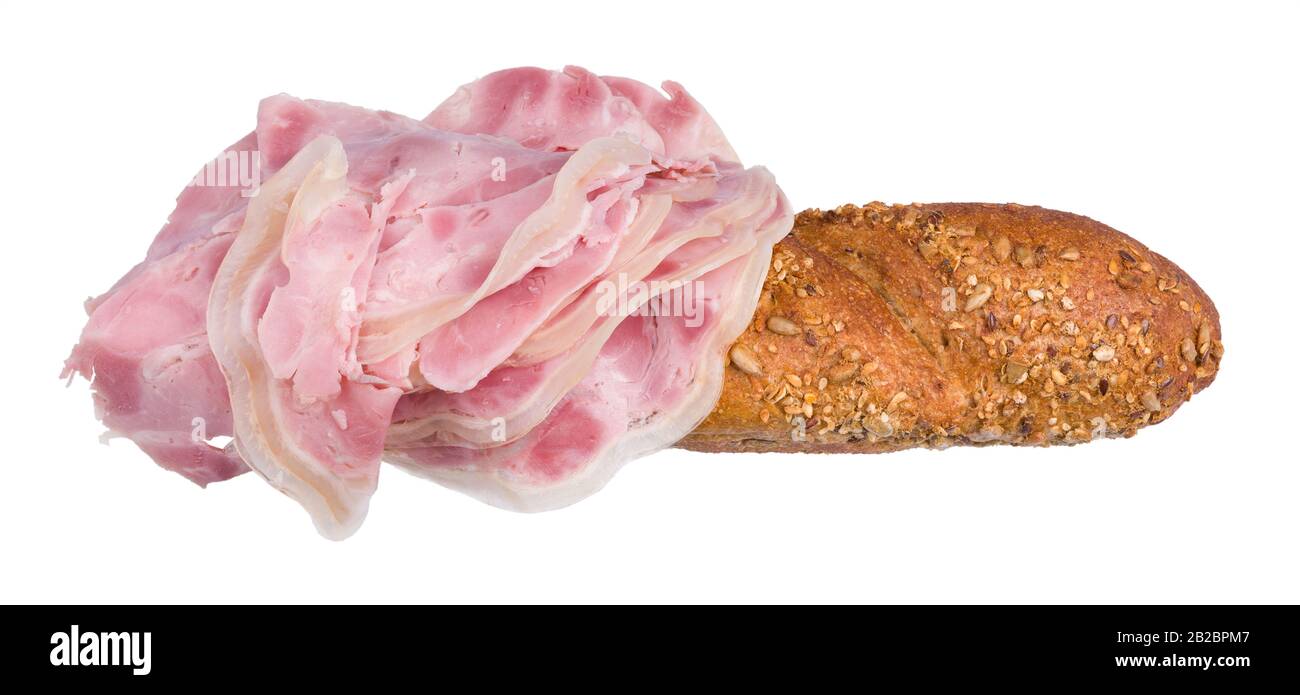 Schinkenscheiben auf Baguette mit goldgebackener Kruste. Nahaufnahme von geschnittenem Schweinefleischknuckle auf frischem Vollkornbaguet mit Sonnenblume und Sesamsamen. Stockfoto