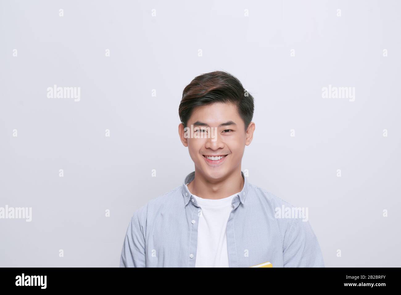 Porträt eines gutaussehenden jungen Mannes mit strahlendem Lächeln auf weißem Hintergrund Stockfoto