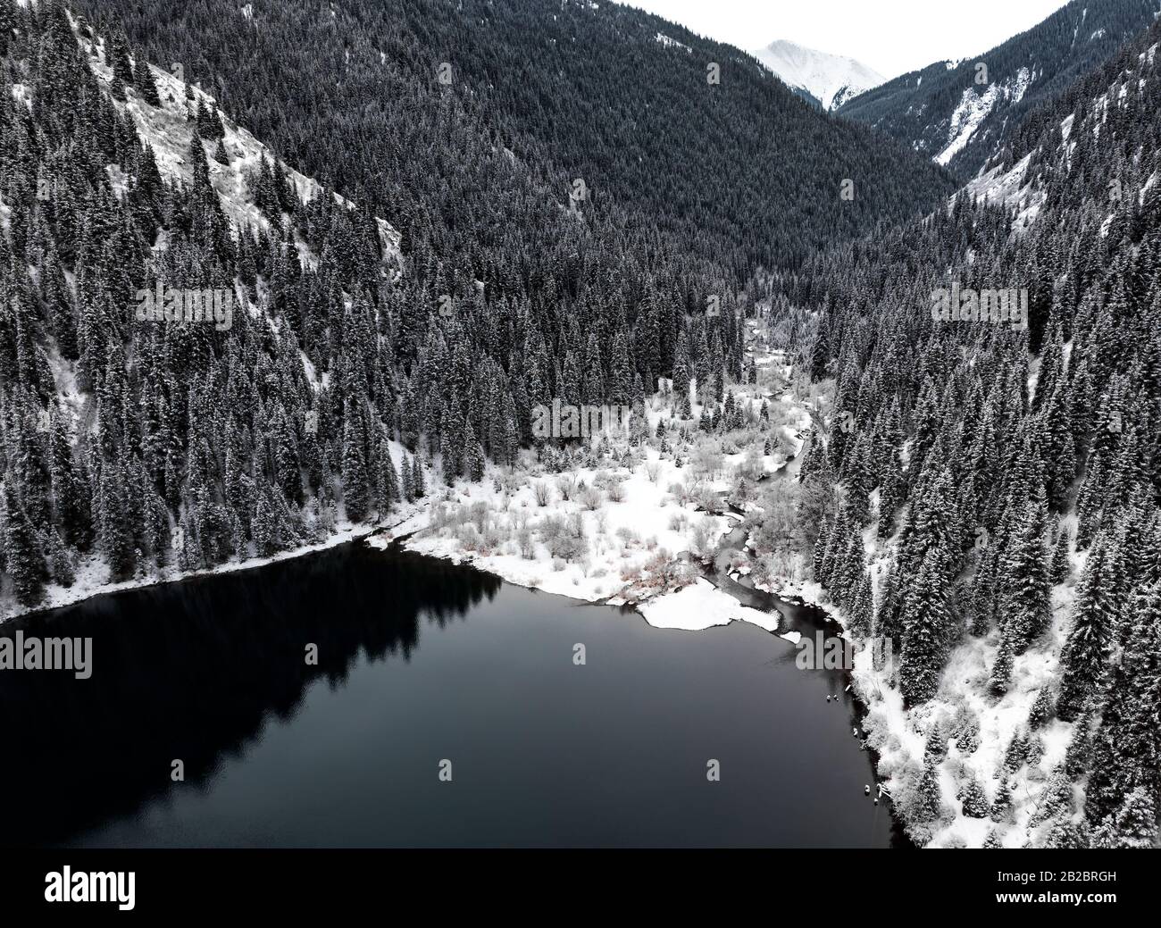 Luftaufnahme von Kolsai-Bergsee und Wald zur Winterzeit in den Bergen von Kazkakhstan. Drohnenschuss, Draufsicht. Stockfoto